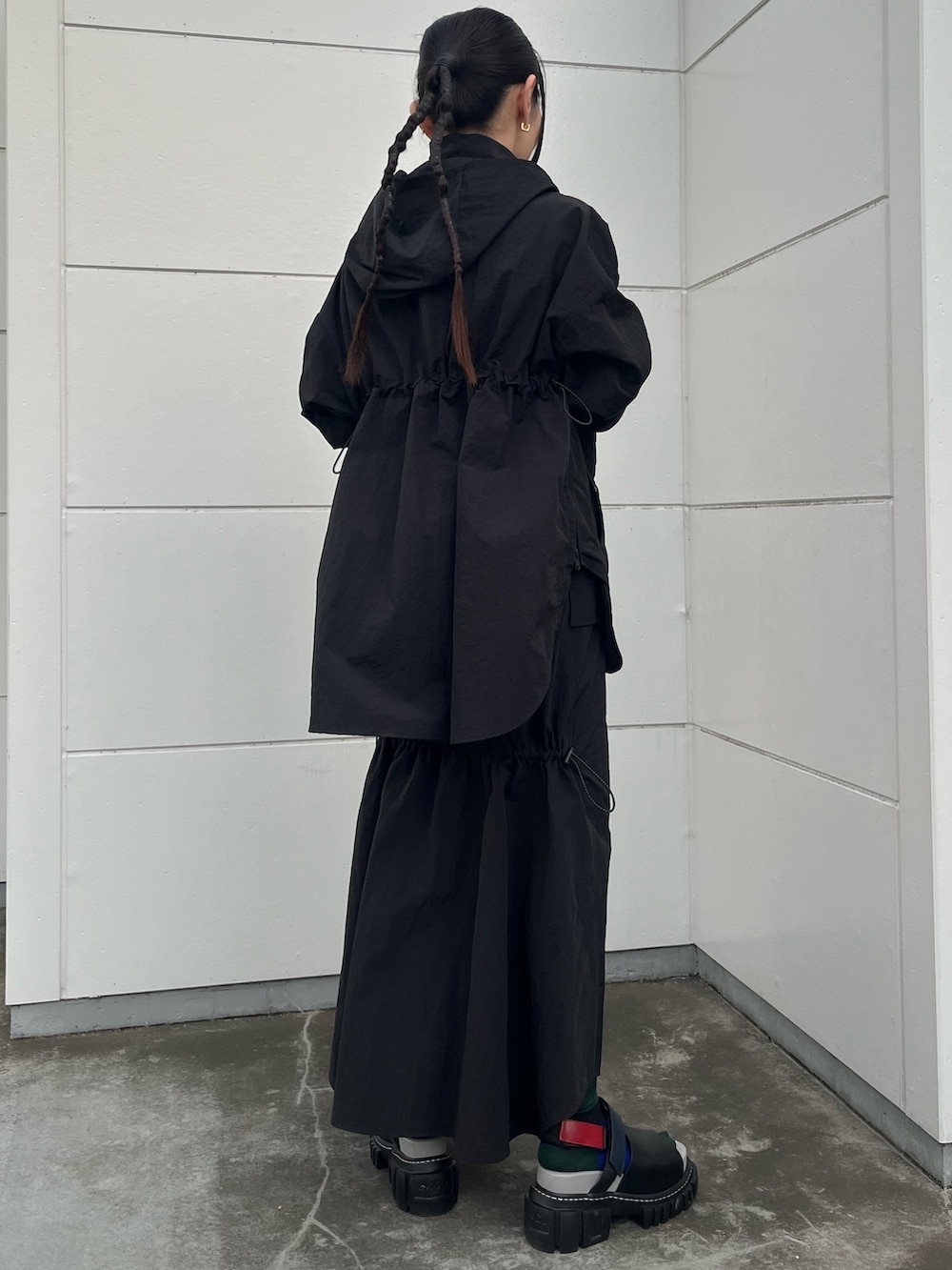 ブラック系のマウンテンパーカー、ブラック系のスカートを着用したレディースの夏コーディネートの4枚目の写真