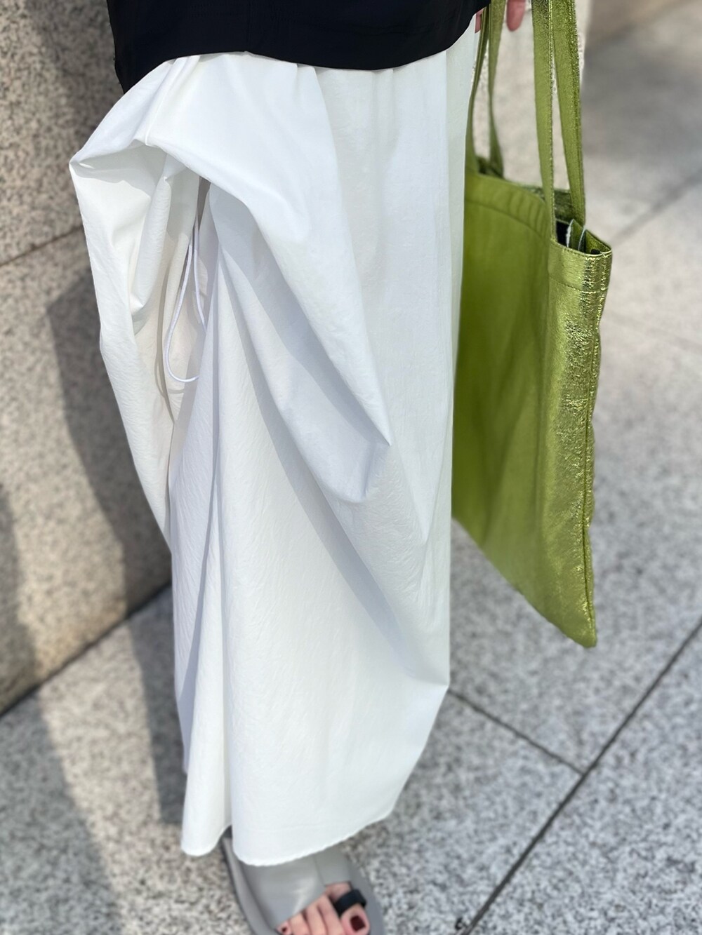 イエロー系のトートバッグ、ブラック系のTシャツ/カットソー、ホワイト系のその他パンツを着用したレディースの春コーディネートの7枚目の写真