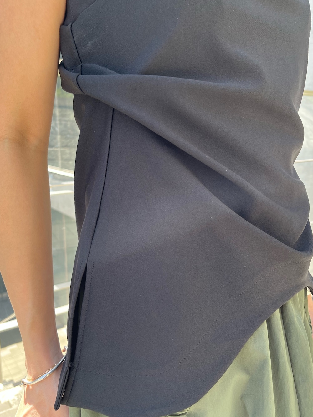 ブラック系のTシャツ/カットソー、グリーン系のスカート、ブラック系のサンダルを着用したレディースの春コーディネートの5枚目の写真