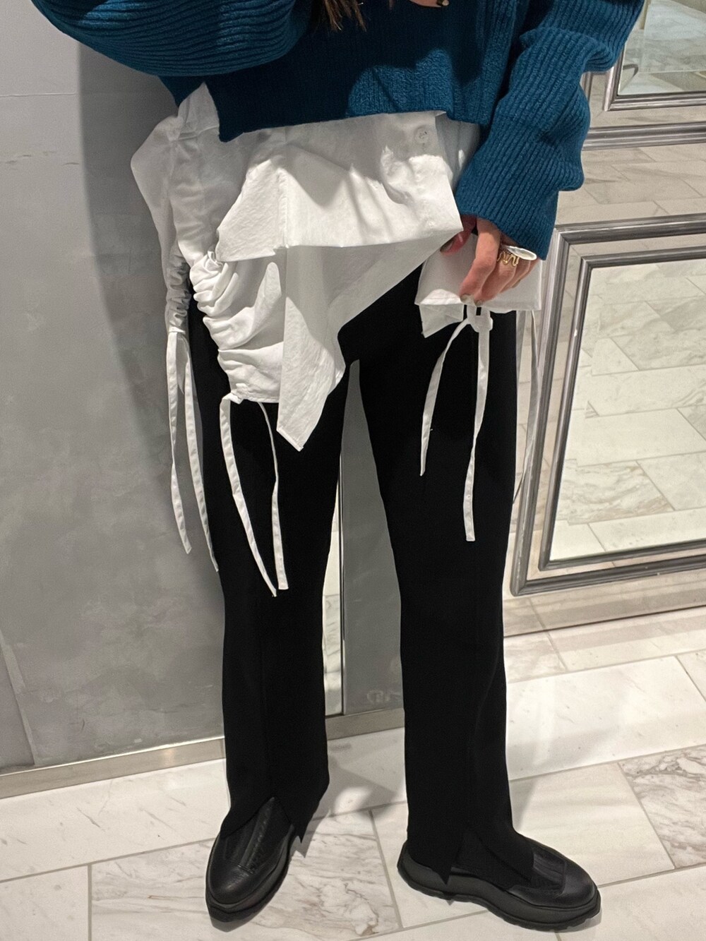 ブラック系のその他パンツ、ホワイト系のキャミソール、ブルー系のニット/セーターを着用したレディースの冬コーディネートの6枚目の写真