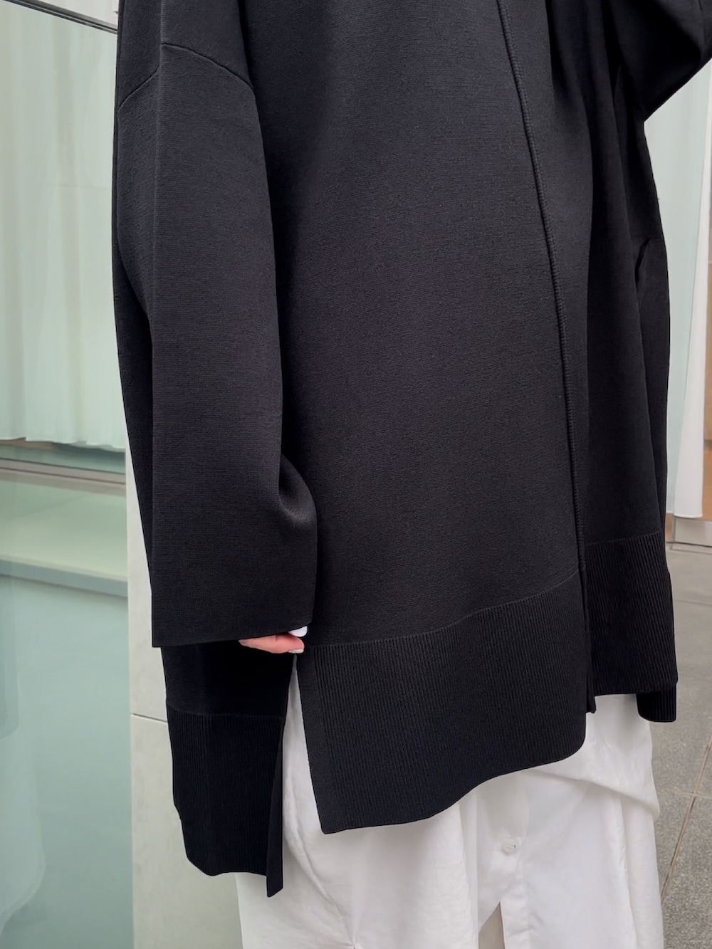 ブラック系のニット/セーター、ホワイト系のワンピース、シルバー系のブーツを着用したレディースの冬コーディネートの4枚目の写真