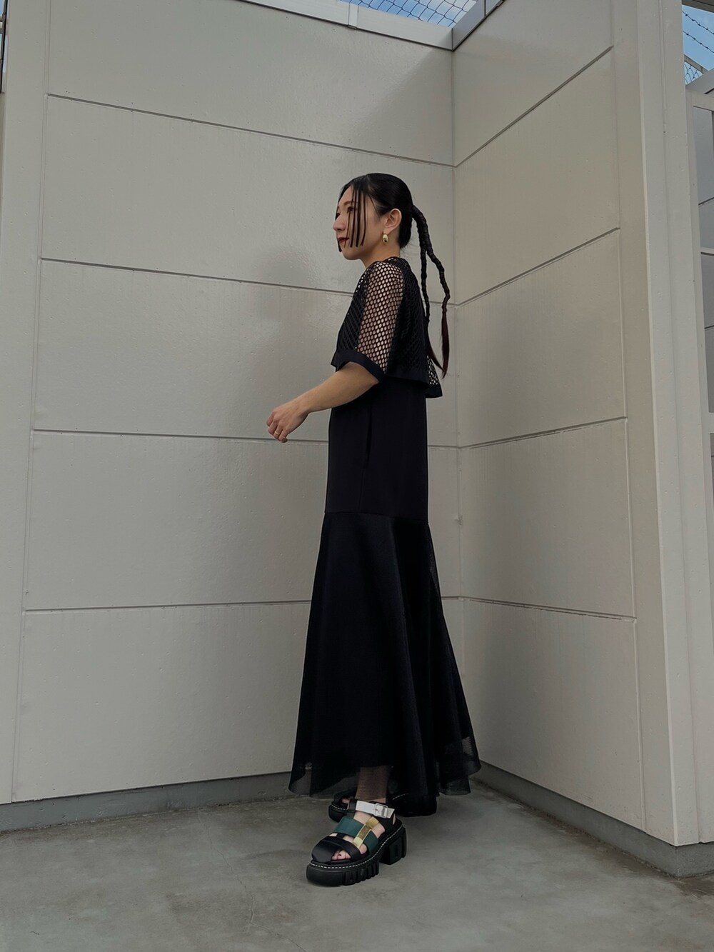 ブラック系のワンピース、その他のサンダル、ゴールド系のネックレスを着用したレディースの春コーディネートの3枚目の写真