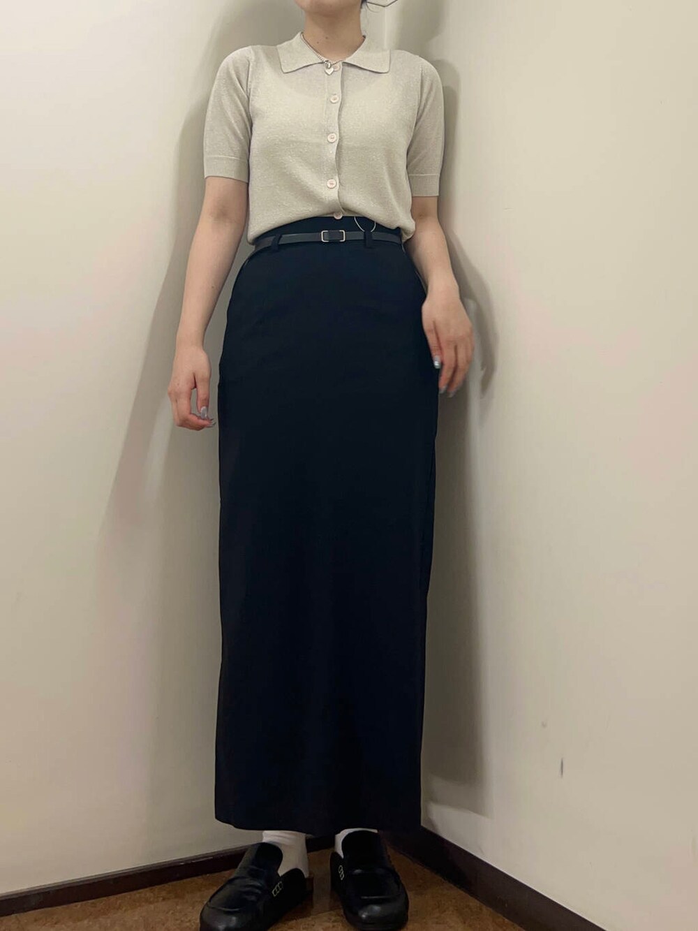 ブラック系のスカート、ホワイト系のニット/セーターを着用したレディースの夏コーディネートの3枚目の写真