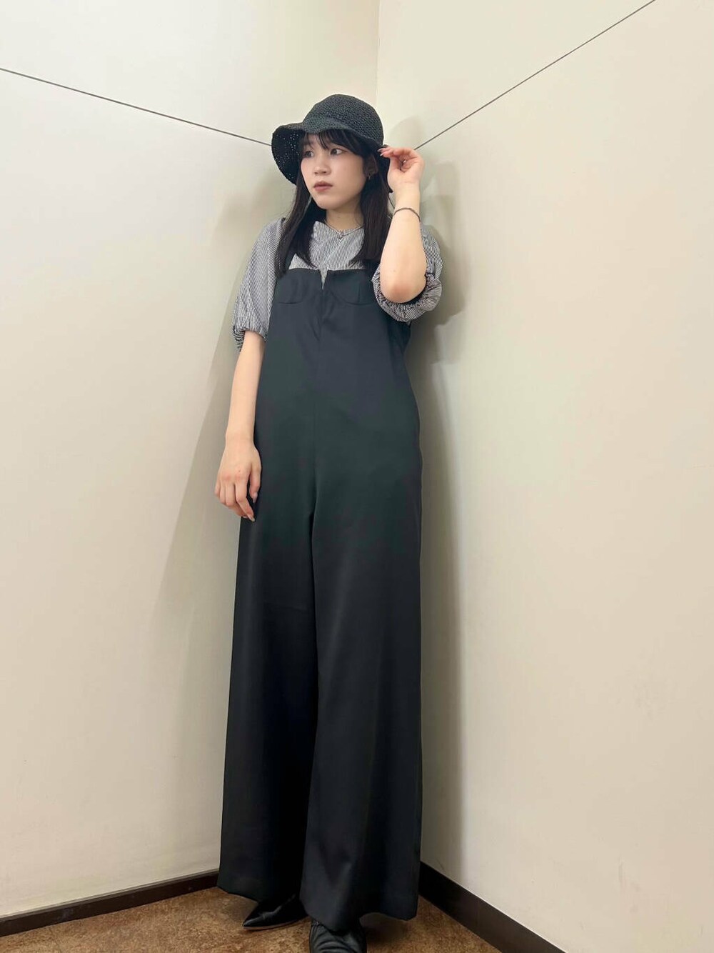 ブラック系のサロペット/オーバーオール、ブルー系のTシャツ/カットソー、ブラック系のハットを着用したレディースの夏コーディネートの4枚目の写真