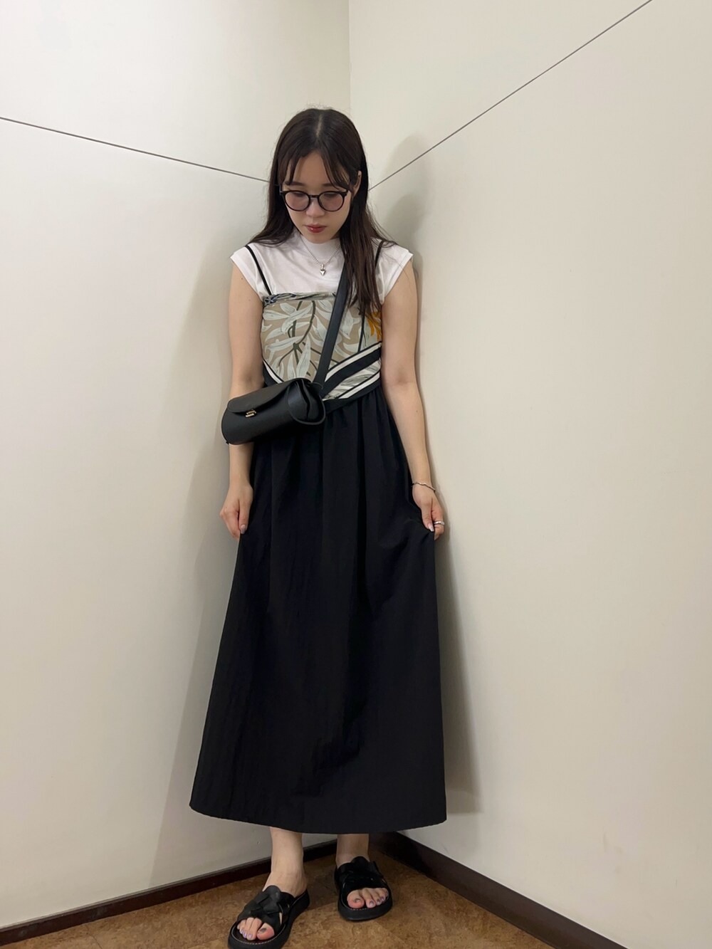 ブラック系のワンピース、ブラック系のショルダーバッグを着用したレディースの夏コーディネートの4枚目の写真