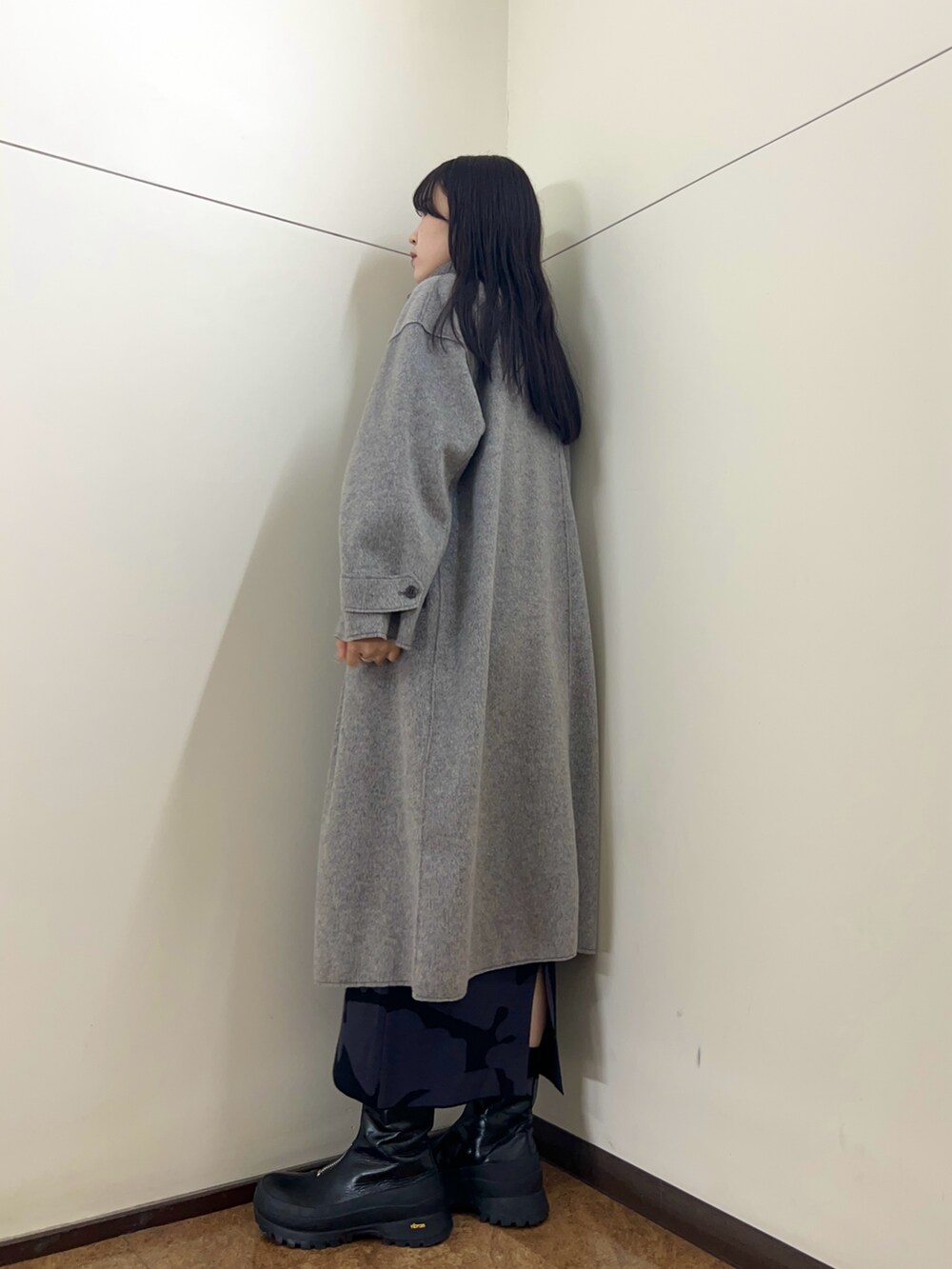 グレー系のその他アウター、ブラック系のスカートを着用したレディースの秋コーディネートの2枚目の写真