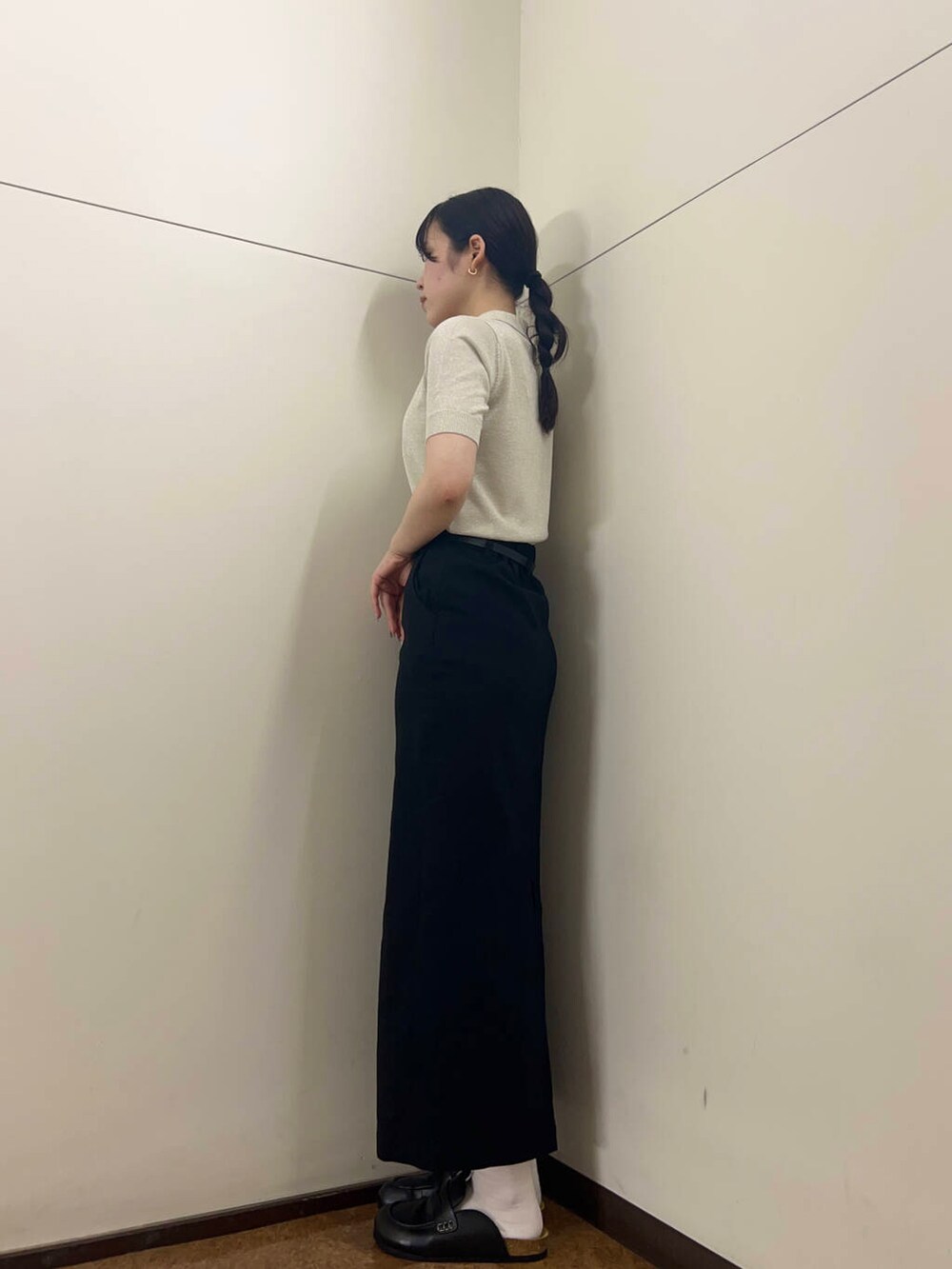 ブラック系のスカート、ホワイト系のニット/セーターを着用したレディースの夏コーディネートの2枚目の写真