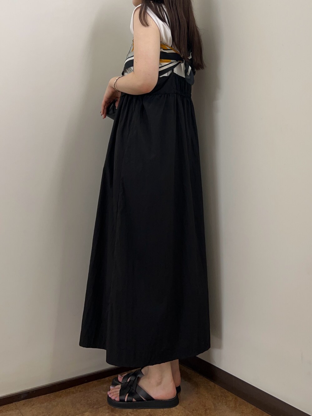 ブラック系のワンピース、ブラック系のショルダーバッグを着用したレディースの夏コーディネートの2枚目の写真