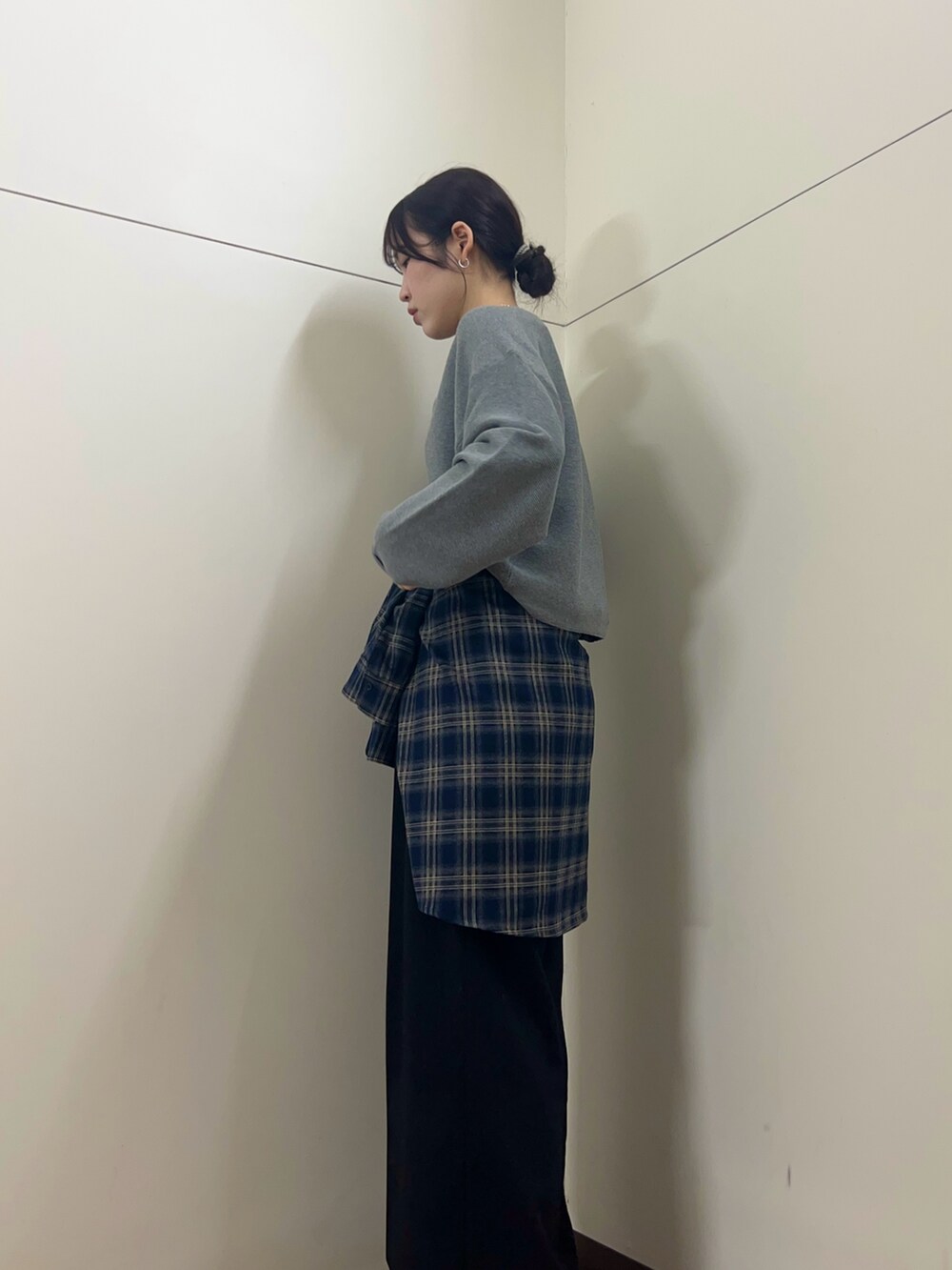 グレー系のニット/セーター、ブルー系のシャツ/ブラウスを着用したレディースの秋コーディネートの2枚目の写真