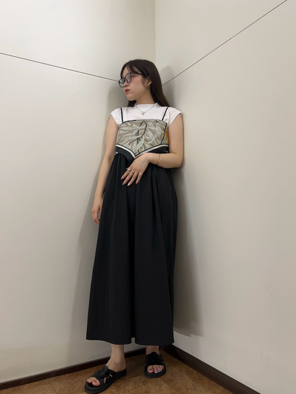 ブラック系のワンピース、ブラック系のショルダーバッグを着用したレディースの夏コーディネートの3枚目の写真