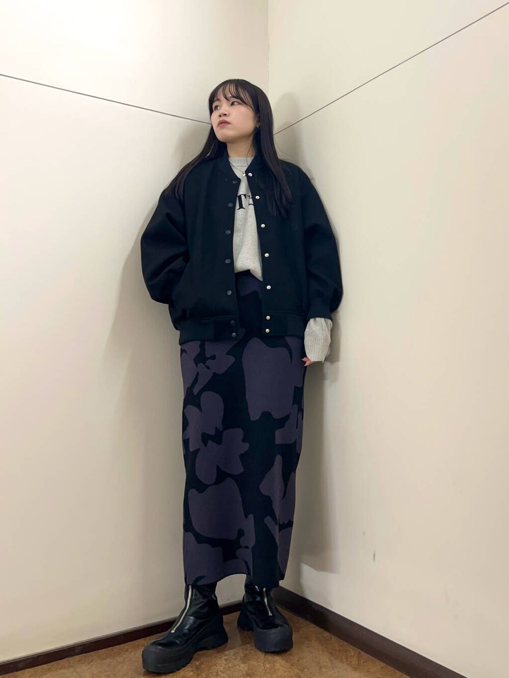 グレー系のニット/セーター、ブラック系のスタジャン、ブラック系のスカートを着用したレディースの秋コーディネートの3枚目の写真