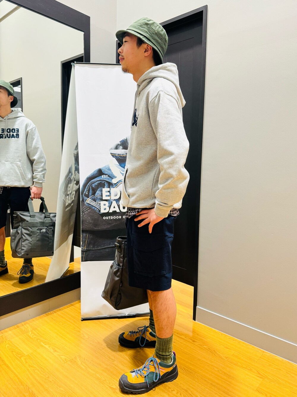 グレー系のバックパック/リュック、グレー系のパーカー、ブルー系のシャツ/ブラウスを着用したメンズの春コーディネートの2枚目の写真