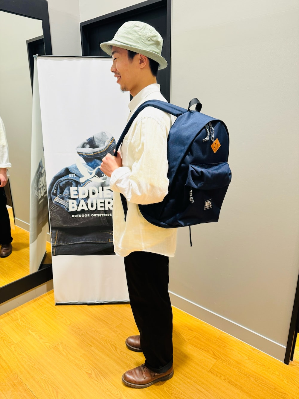 イエロー系のTシャツ/カットソー、ブルー系のバックパック/リュック、ホワイト系のシャツ/ブラウスを着用したメンズの春コーディネートの2枚目の写真