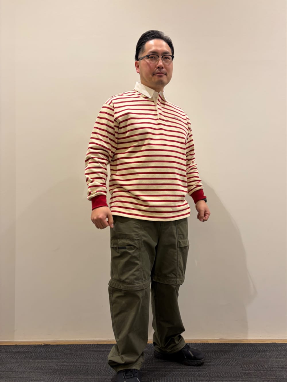 ブルー系のブルゾン、レッド系のポロシャツ、グリーン系のその他パンツを着用したメンズの冬コーディネートの4枚目の写真