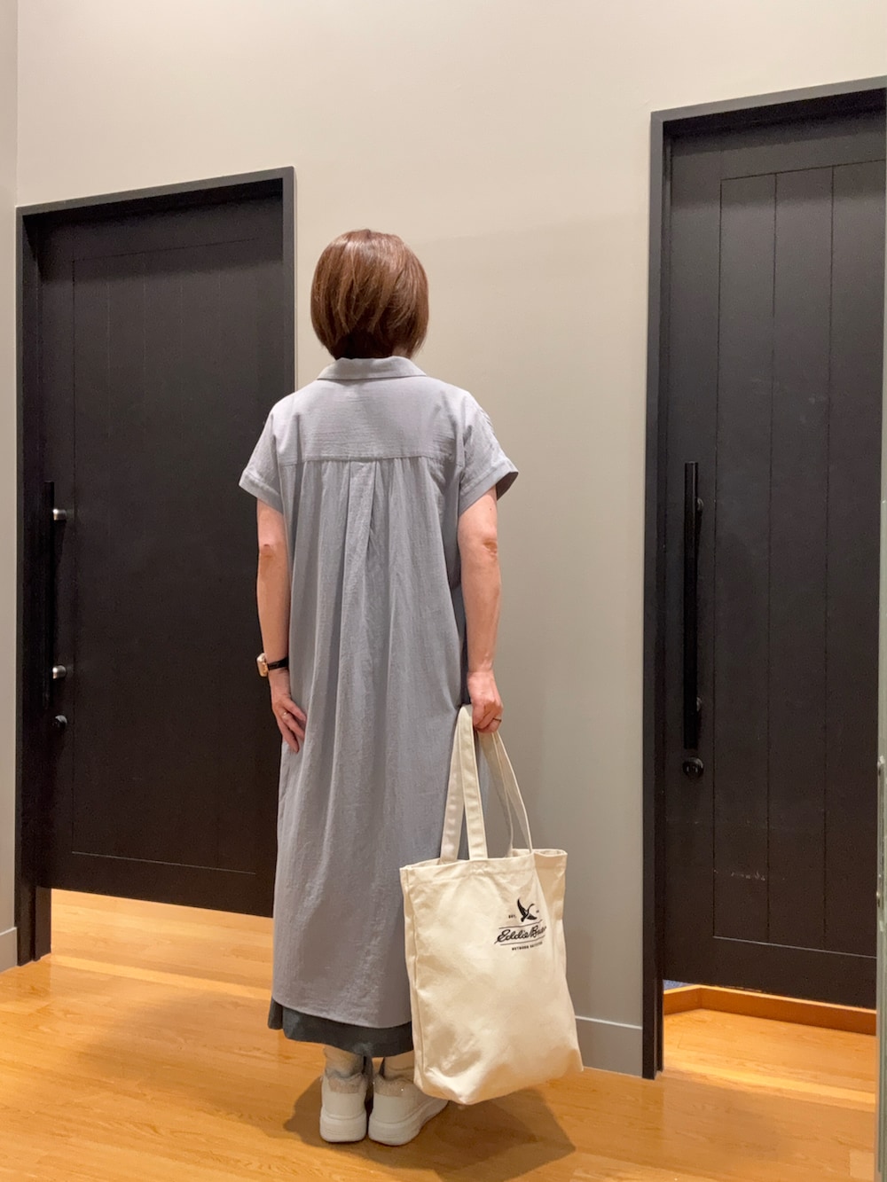 ホワイト系のトートバッグ、グレー系のシャツワンピース、ホワイト系のTシャツ/カットソーを着用したレディースの夏コーディネートの2枚目の写真