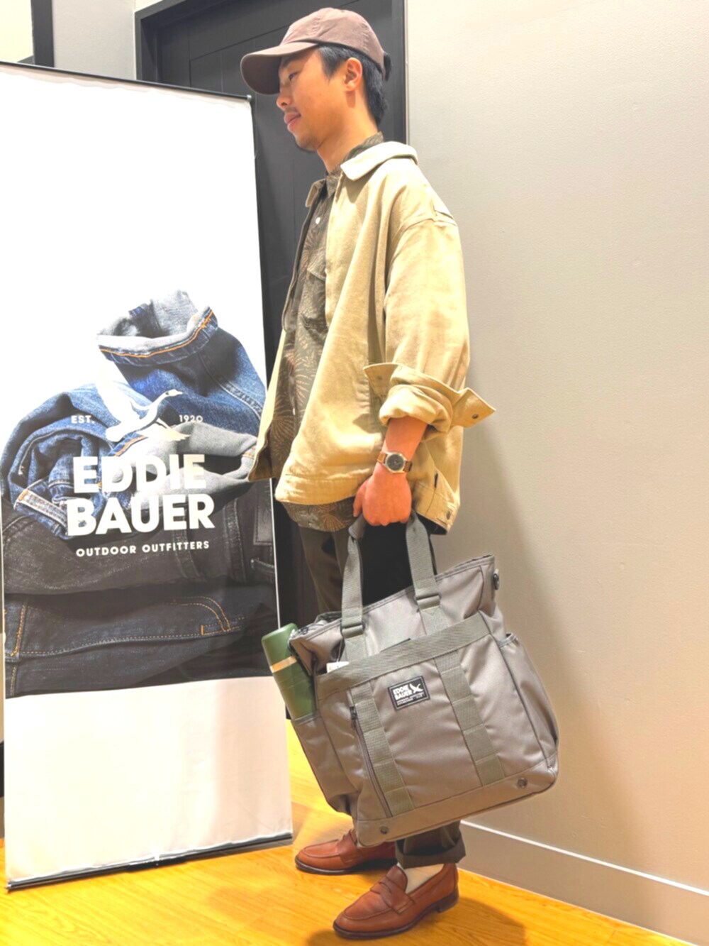 グレー系のバックパック/リュック、ベージュ系のブルゾン、グリーン系のチノパンツを着用したメンズの春コーディネートの3枚目の写真