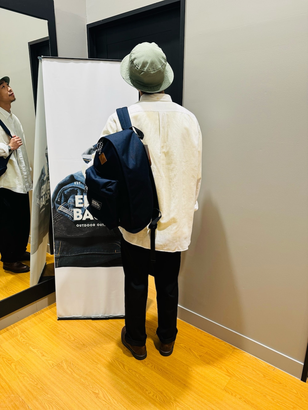 イエロー系のTシャツ/カットソー、ブルー系のバックパック/リュック、ホワイト系のシャツ/ブラウスを着用したメンズの春コーディネートの3枚目の写真