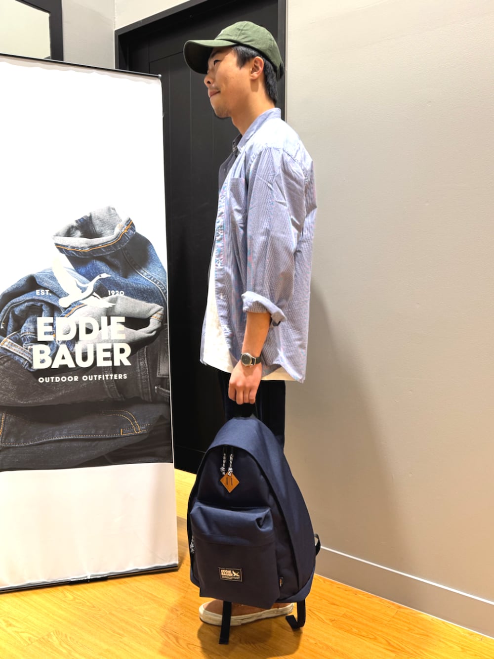 ブルー系のバックパック/リュック、ブルー系のシャツ/ブラウス、ホワイト系のTシャツ/カットソーを着用したメンズの春コーディネートの2枚目の写真
