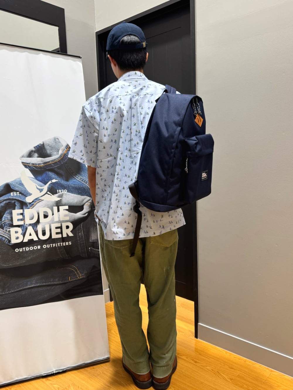 ブルー系のバックパック/リュック、ブルー系のシャツ/ブラウス、ホワイト系のTシャツ/カットソーを着用したメンズの春コーディネートの3枚目の写真