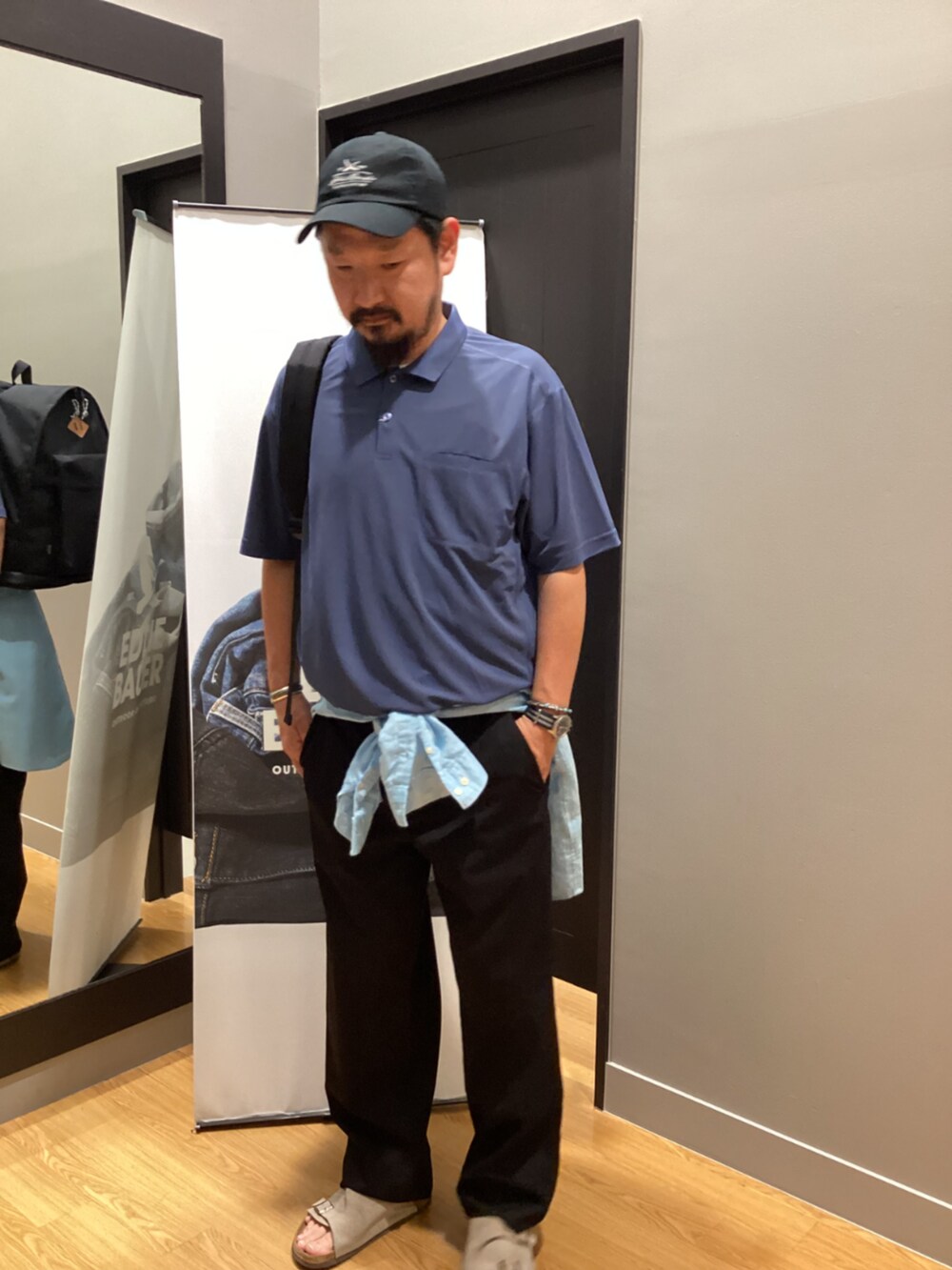 ブラック系のバックパック/リュック、ブルー系のポロシャツ、ブルー系のシャツ/ブラウスを着用したメンズの夏コーディネートの5枚目の写真