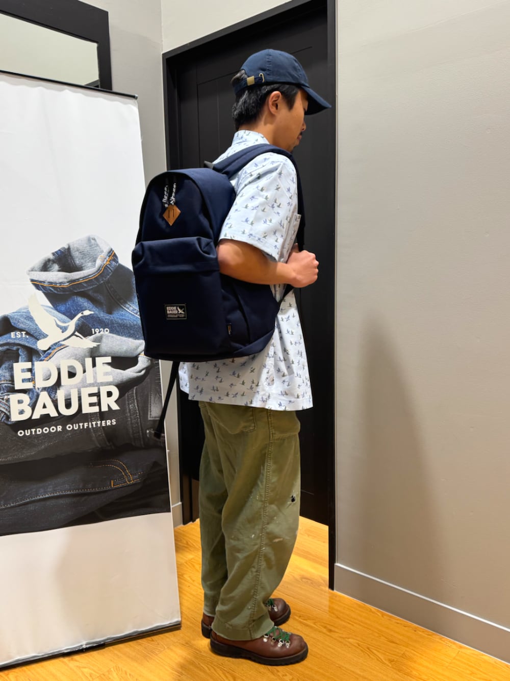 ブルー系のバックパック/リュック、ブルー系のシャツ/ブラウス、ホワイト系のTシャツ/カットソーを着用したメンズの春コーディネートの2枚目の写真