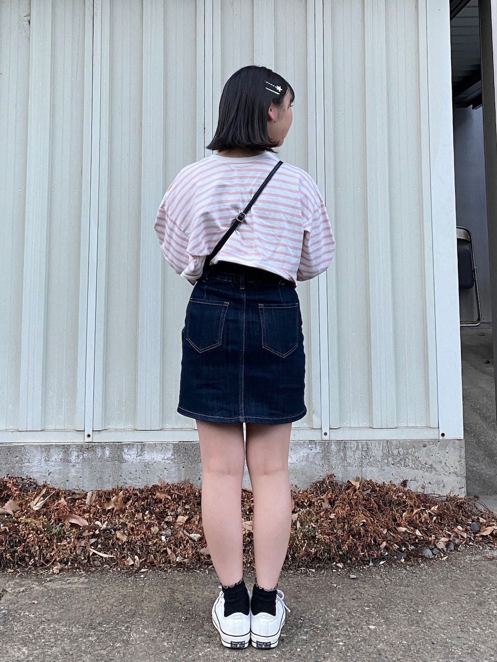 ピンク系のTシャツ/カットソー、ブルー系のスカート、ホワイト系のスニーカーを着用したレディースの冬コーディネートの3枚目の写真