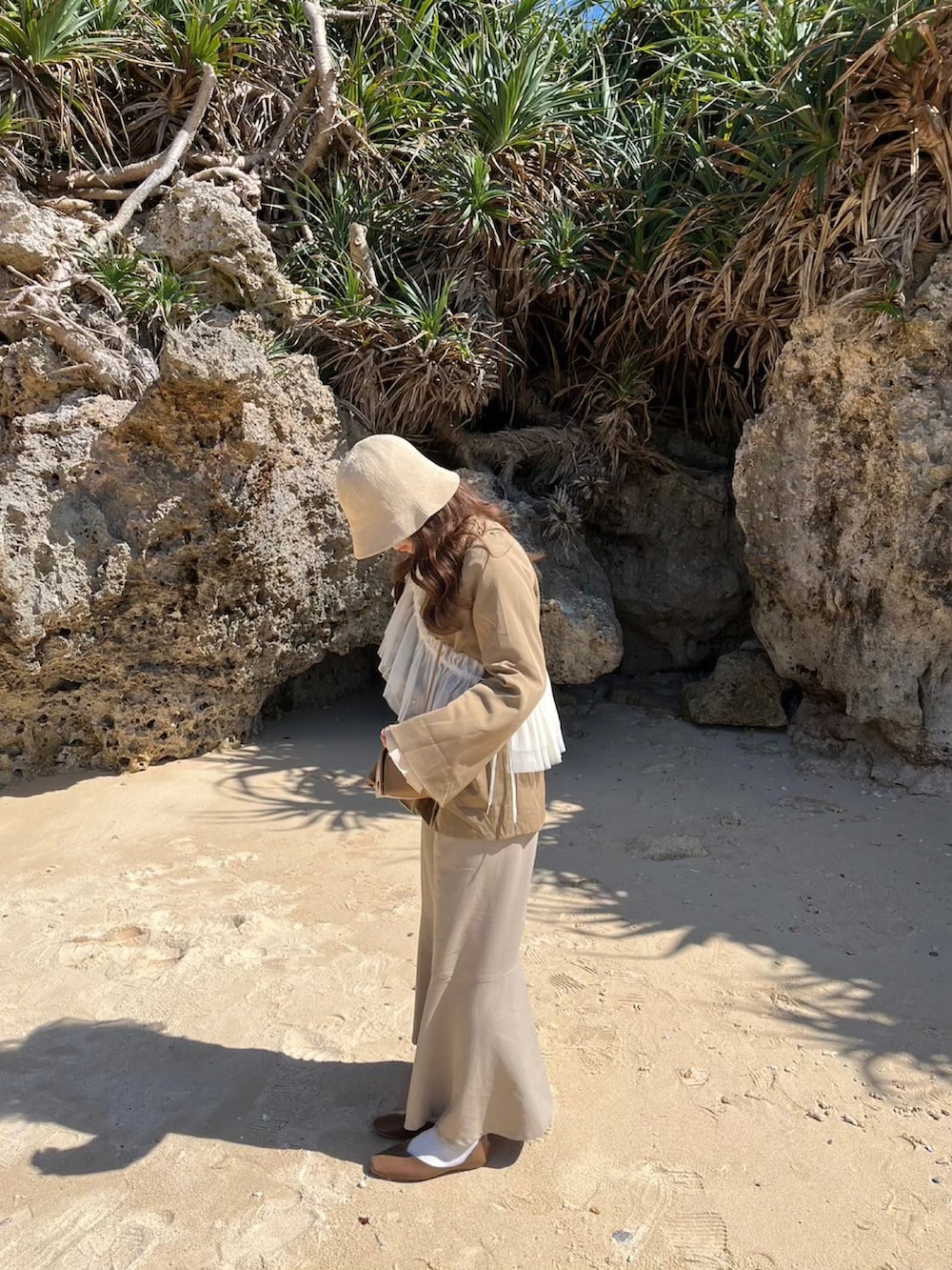 ホワイト系のスカート、ブラウン系のバレエシューズ、ベージュ系のテーラードジャケットを着用したレディースの夏コーディネートの2枚目の写真