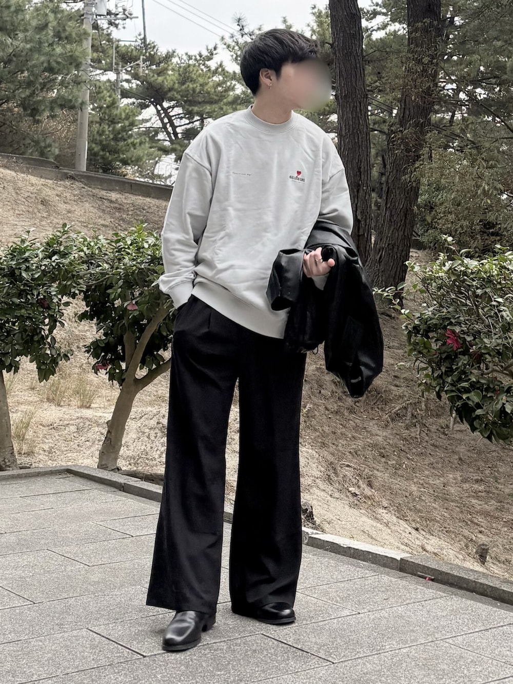 ブラック系のスラックス、ブラック系のブーツ、ブラック系のブルゾンを着用したメンズの冬コーディネートの2枚目の写真