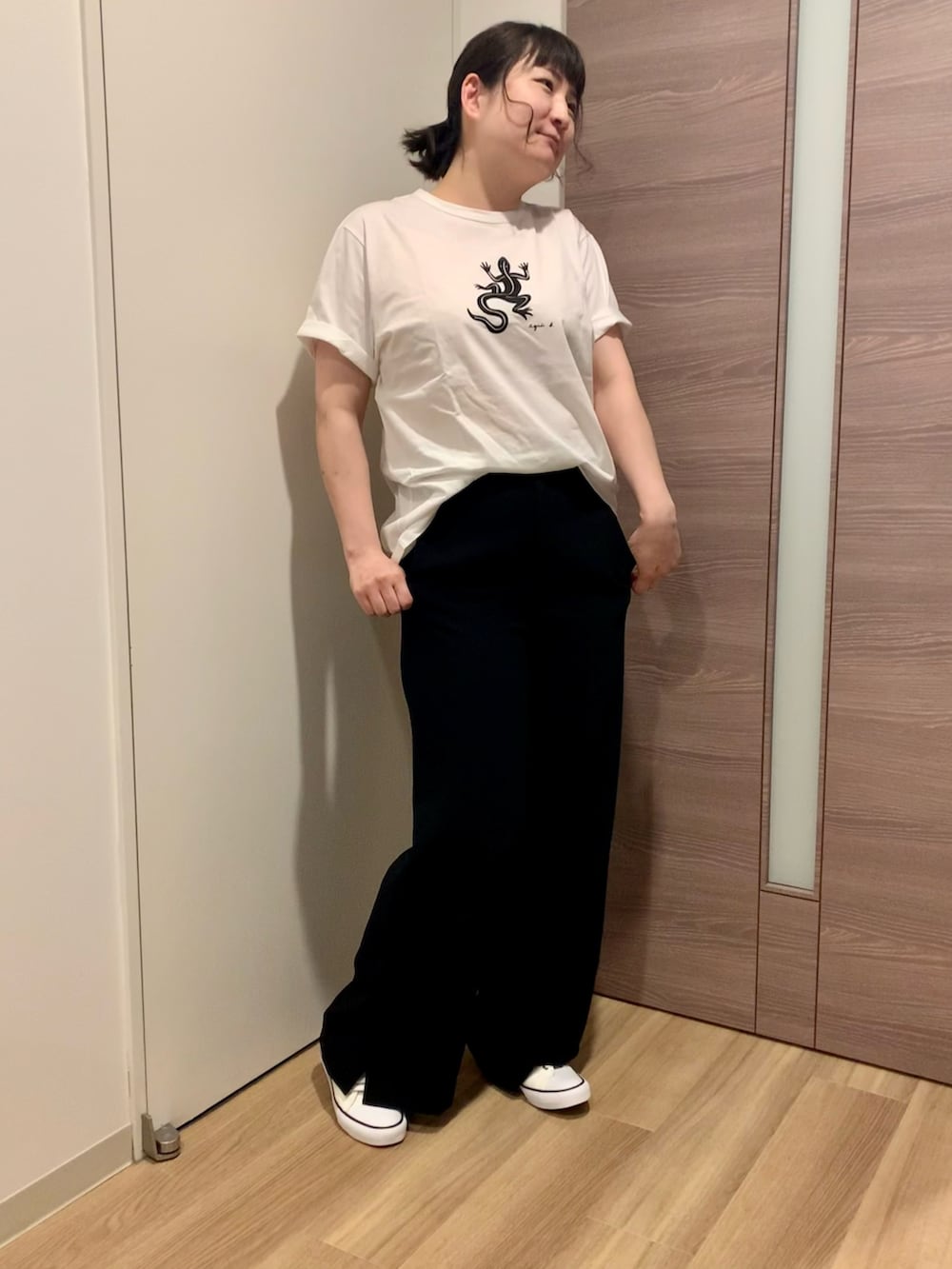 ホワイト系のTシャツ/カットソー、ブラック系のパンツ、ホワイト系のスニーカーを着用したレディースの春コーディネートの2枚目の写真