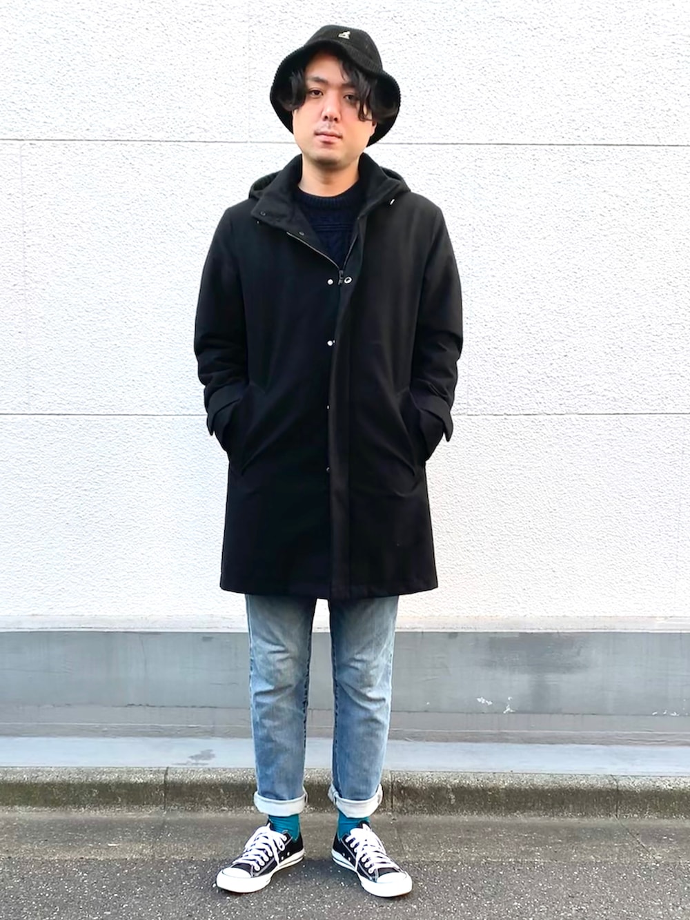 ブラック系のモッズコート、ブルー系のデニムパンツ、ブラック系のスニーカーを着用したメンズの秋コーディネートの2枚目の写真