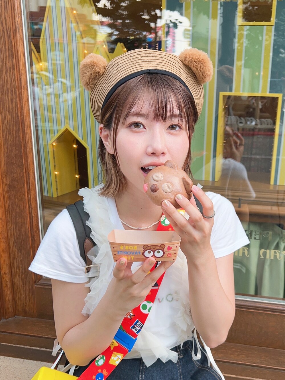 ブルー系のデニムスカート、ブラウン系のサンダル、ホワイト系のキャミソールを着用したレディースの秋コーディネートの3枚目の写真