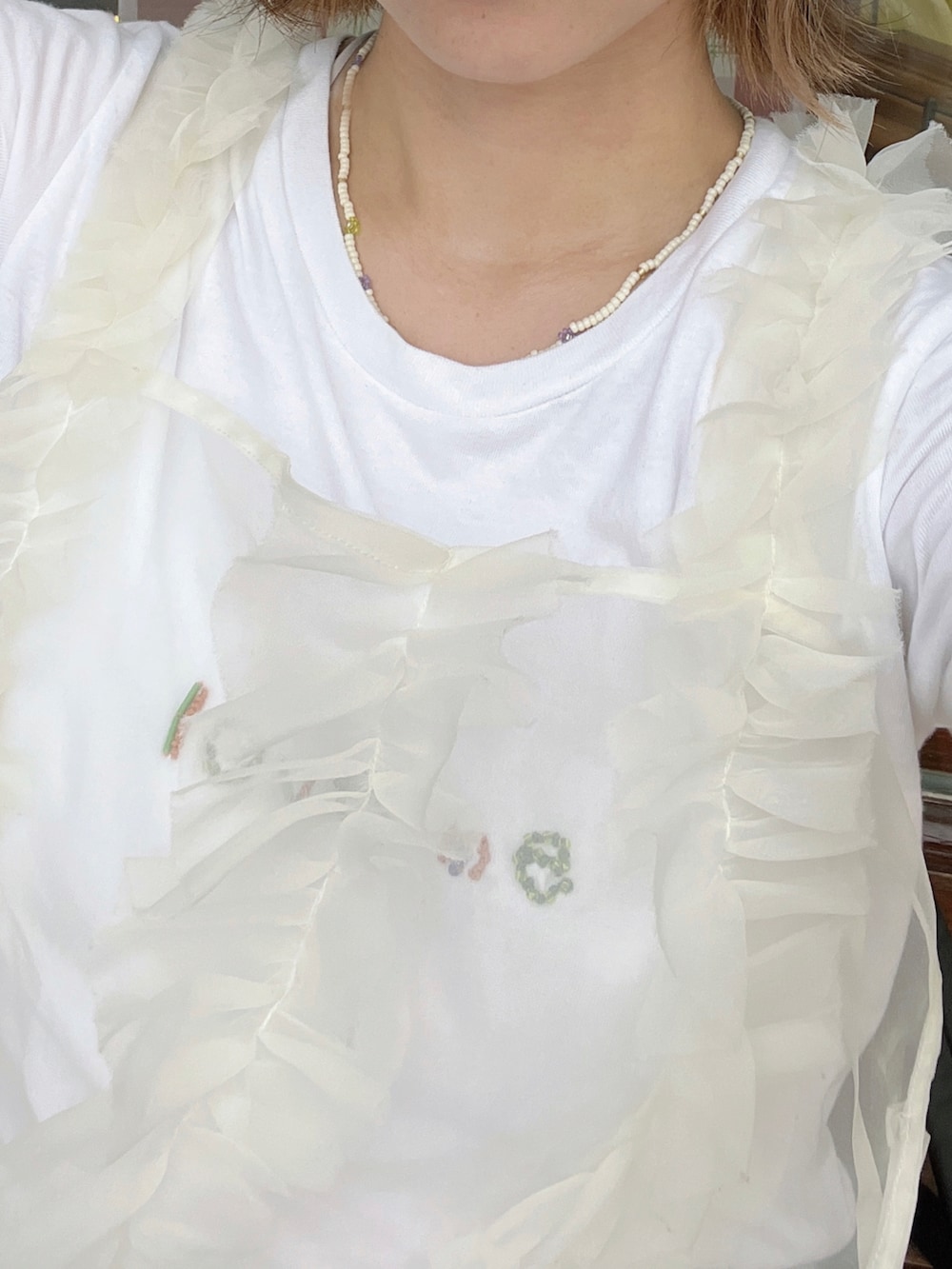 ブルー系のデニムスカート、ブラウン系のサンダル、ホワイト系のキャミソールを着用したレディースの秋コーディネートの2枚目の写真