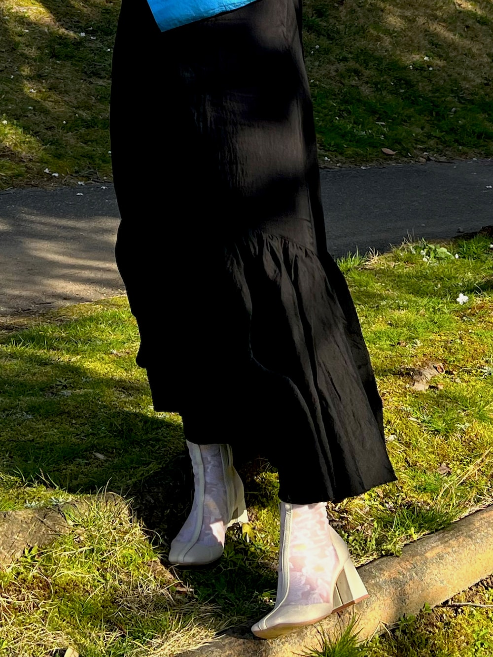 ブラック系のワンピース、ベージュ系のブーツ、ブルー系のシャツ/ブラウスを着用したレディースの春コーディネートの3枚目の写真