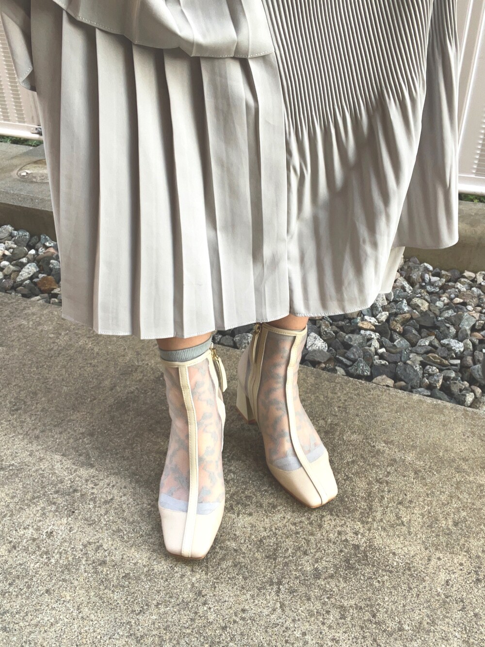 グレー系のカーディガン/ボレロ、グレー系のスカート、ブラウン系のショルダーバッグを着用したレディースの春コーディネートの2枚目の写真