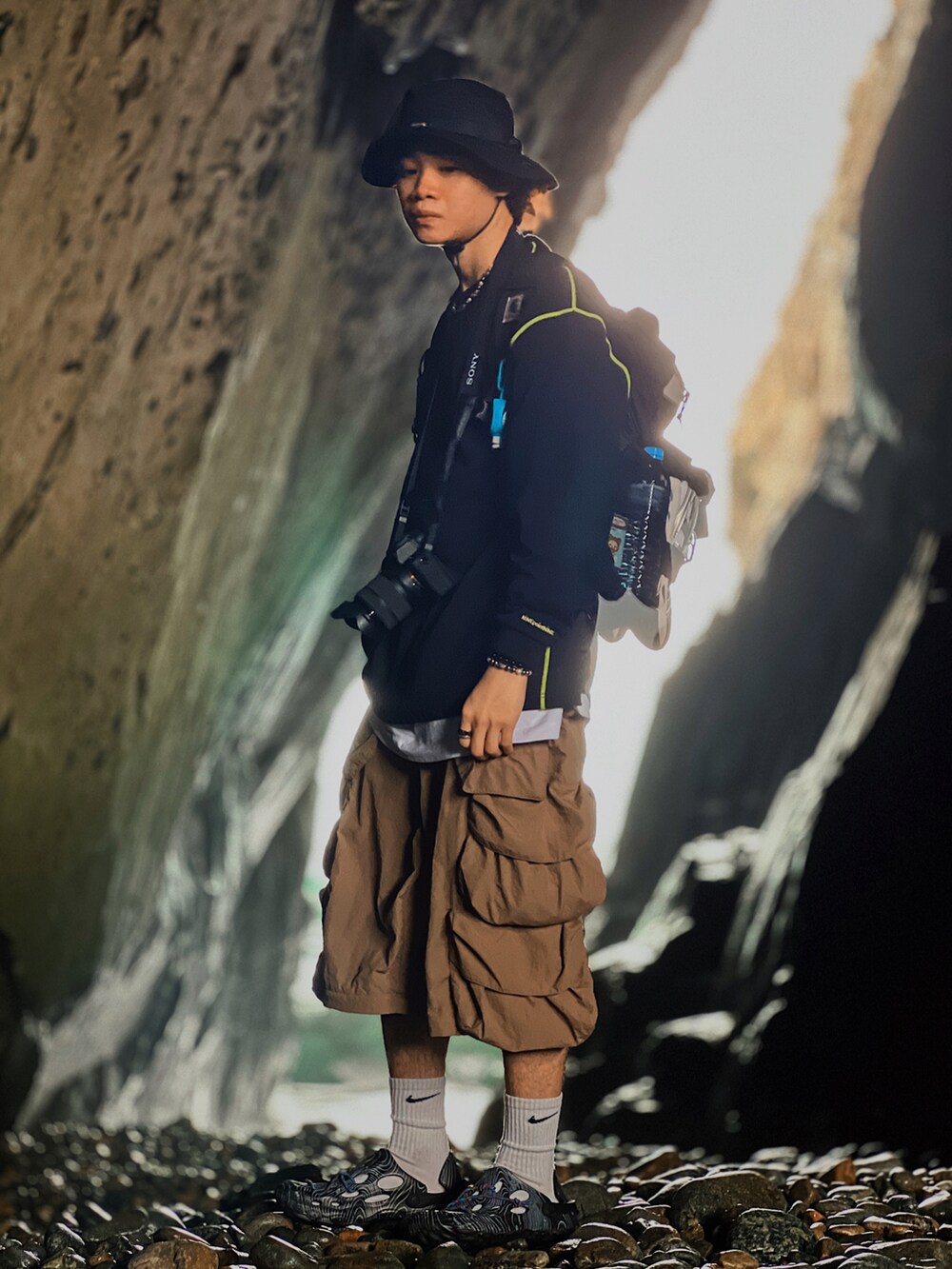 ブラック系のスウェット、ブラウン系のカーゴパンツ、ブラック系のスリッポンを着用したメンズの春コーディネートの3枚目の写真