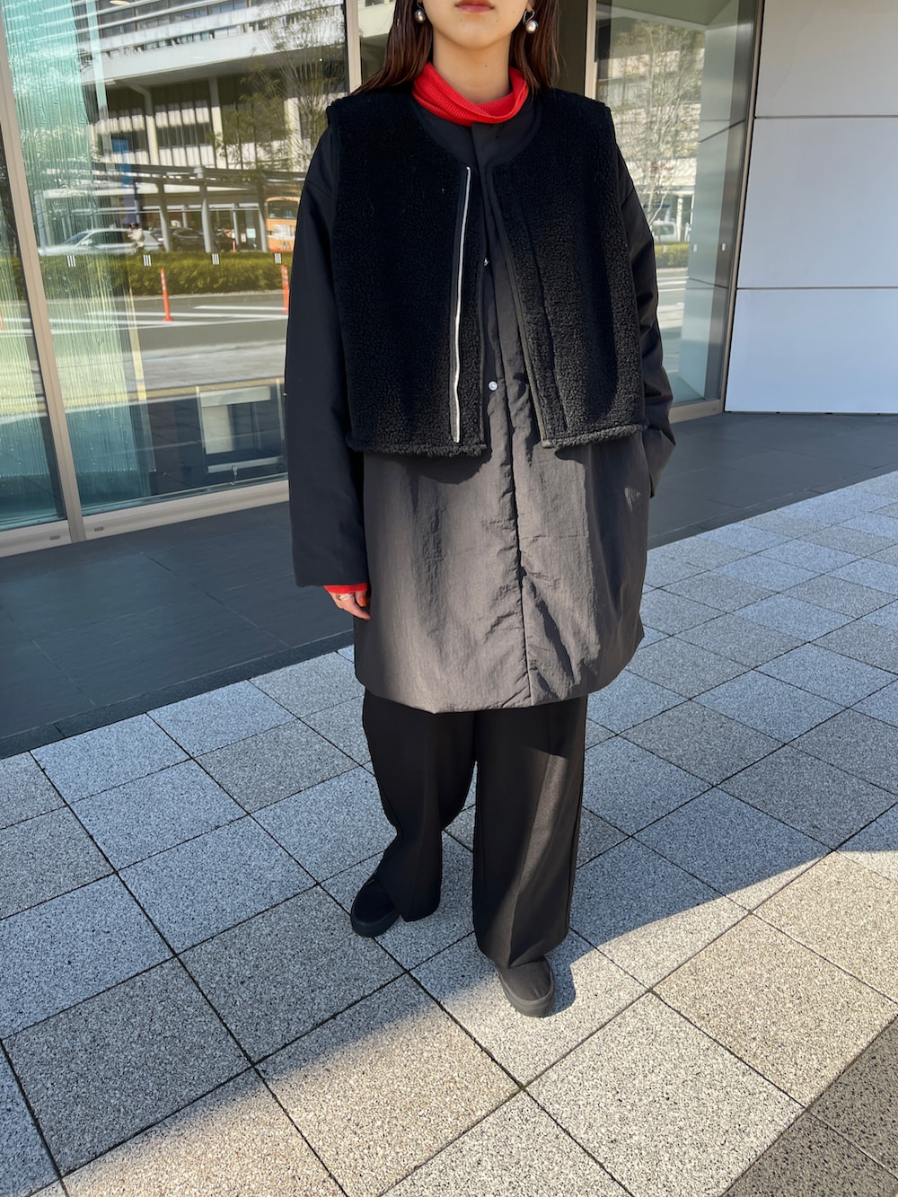 ブラック系のその他アウター、ブラック系のその他パンツ、ブラック系のスニーカーを着用したレディースの冬コーディネートの3枚目の写真