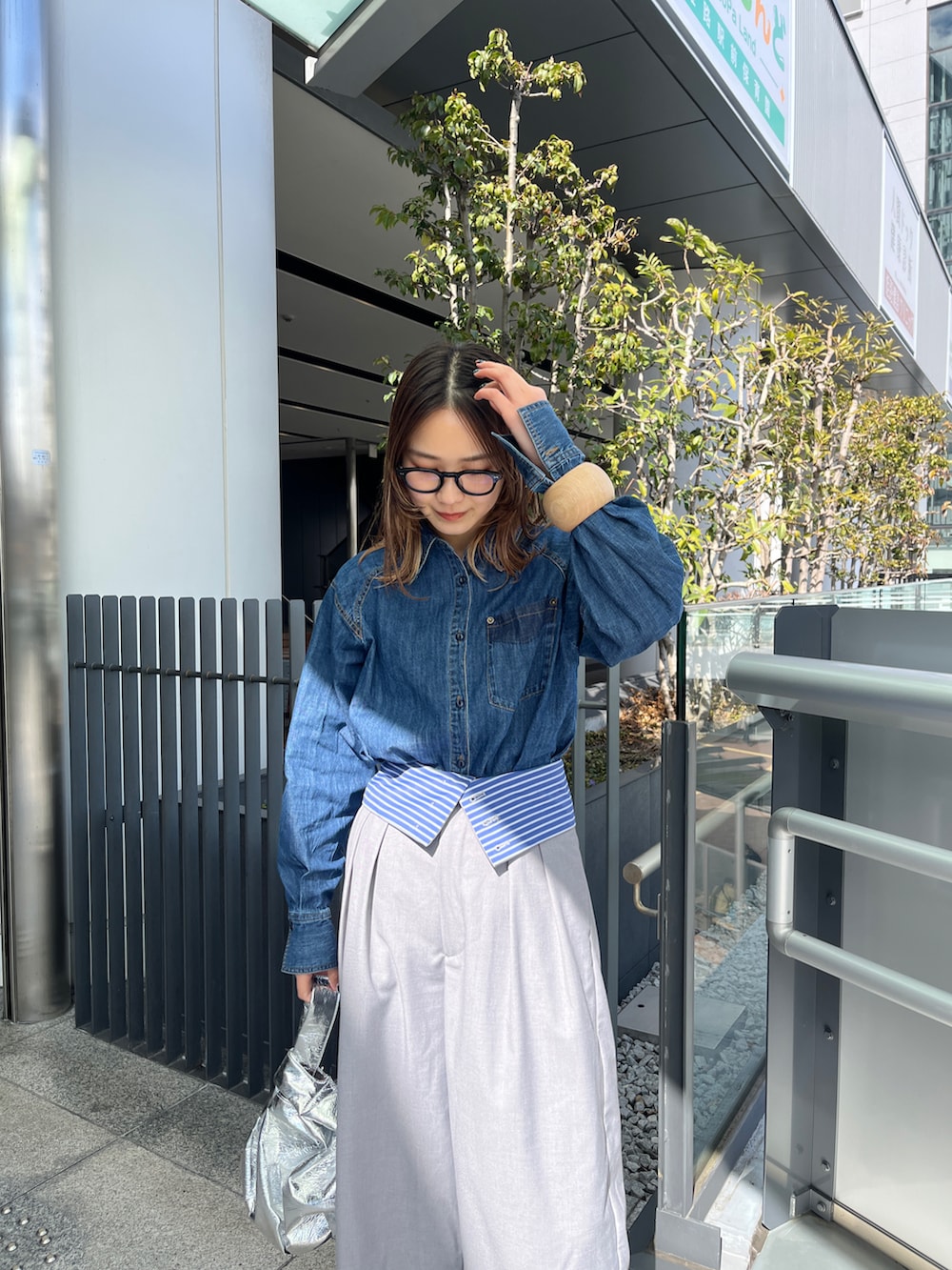 ブルー系のシャツ/ブラウス、グレー系のその他パンツ、ブラック系のブーツを着用したレディースの春コーディネートの3枚目の写真