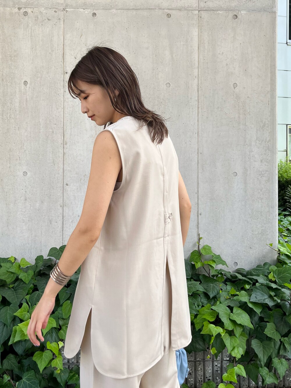 ベージュ系のセットアップ、ベージュ系のサンダル、ブルー系のショルダーバッグを着用したレディースの夏コーディネートの3枚目の写真