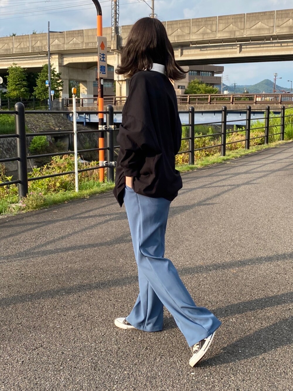 グレー系のスラックスを着用したレディースの夏コーディネートの2枚目の写真