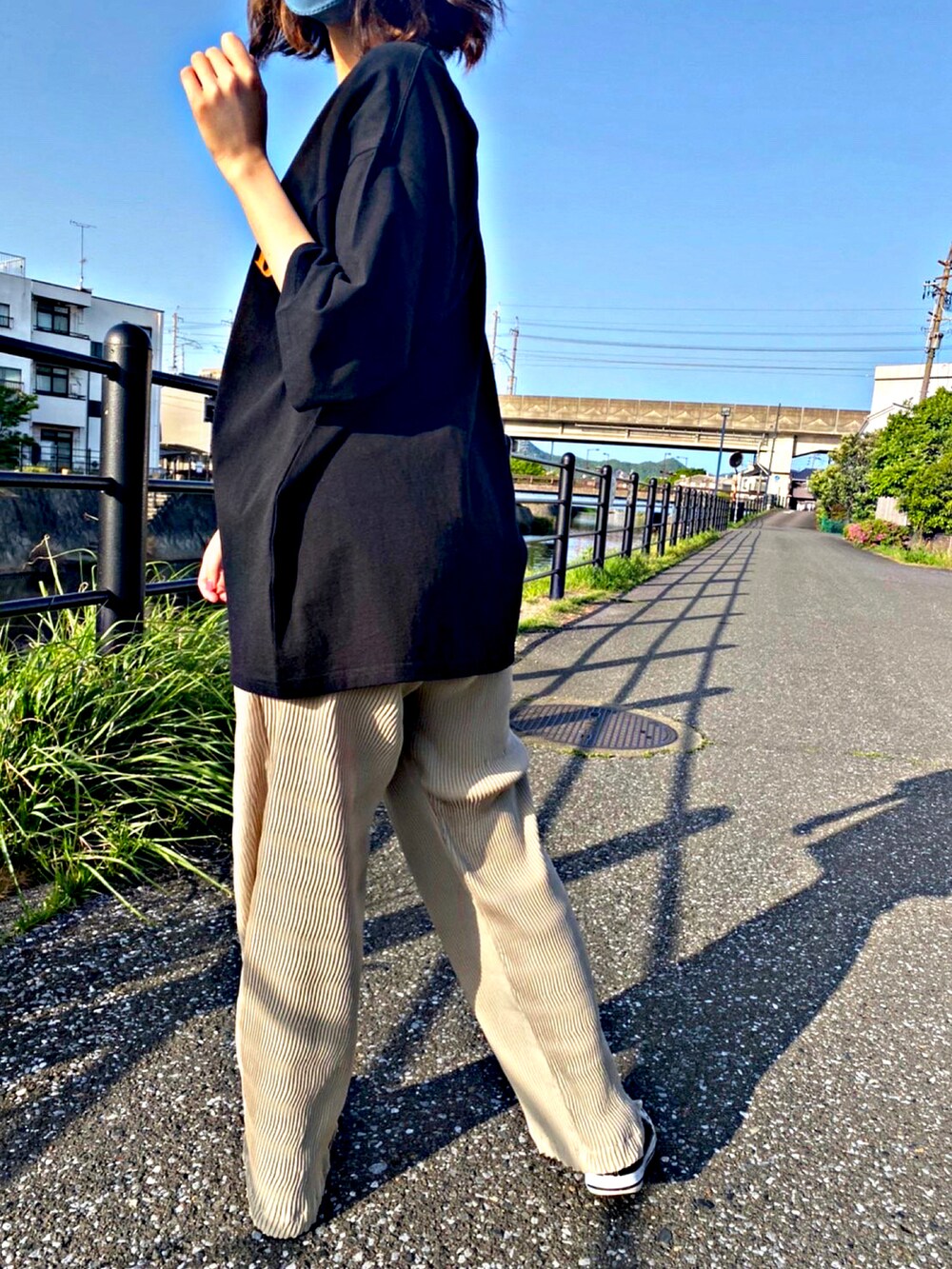 ブラック系のTシャツ/カットソー、ブラック系のスニーカー、ベージュ系のその他パンツを着用したレディースの春コーディネートの2枚目の写真