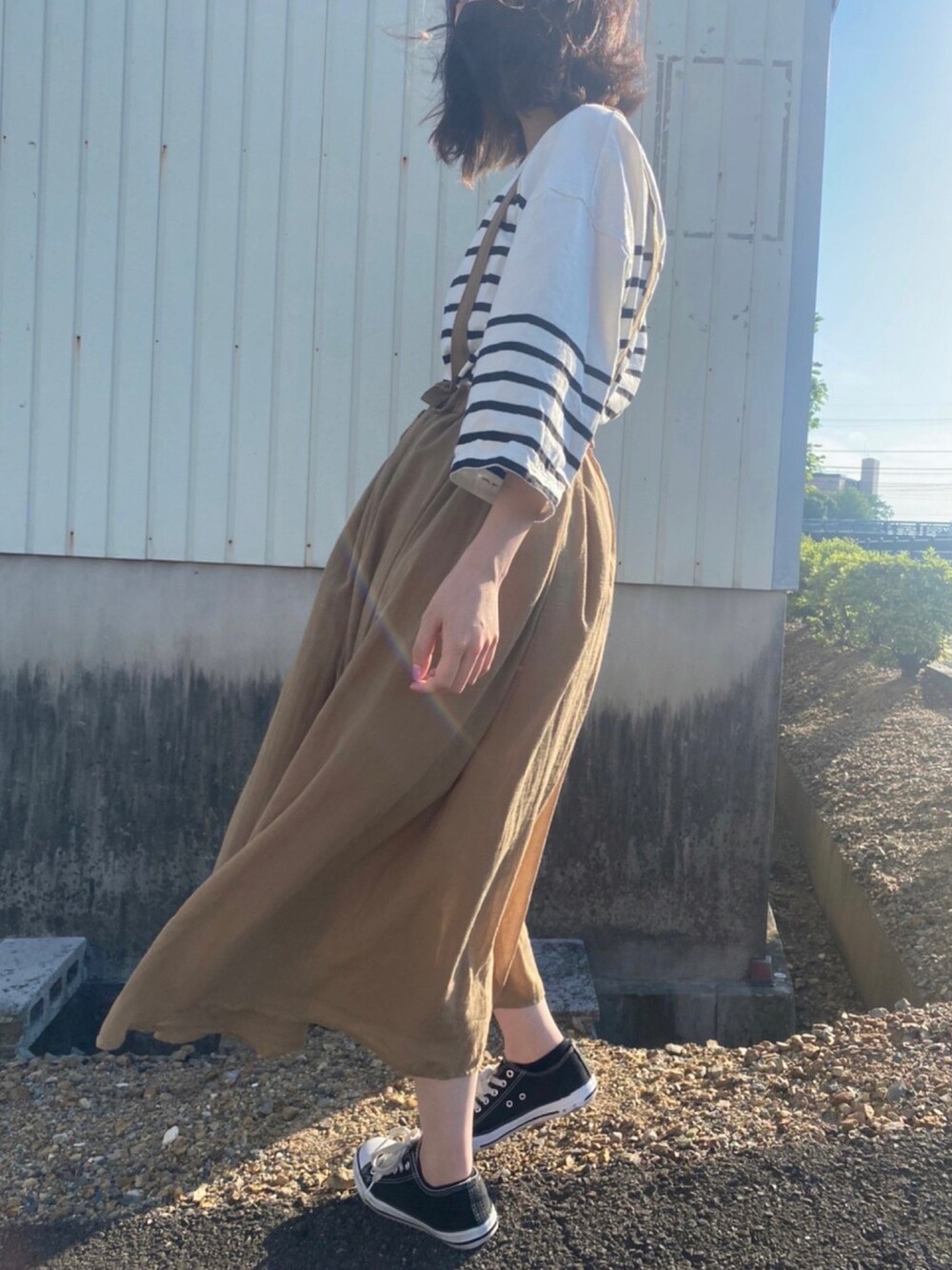 ブラック系のTシャツ/カットソー、ブラック系のスニーカーを着用したレディースの春コーディネートの2枚目の写真