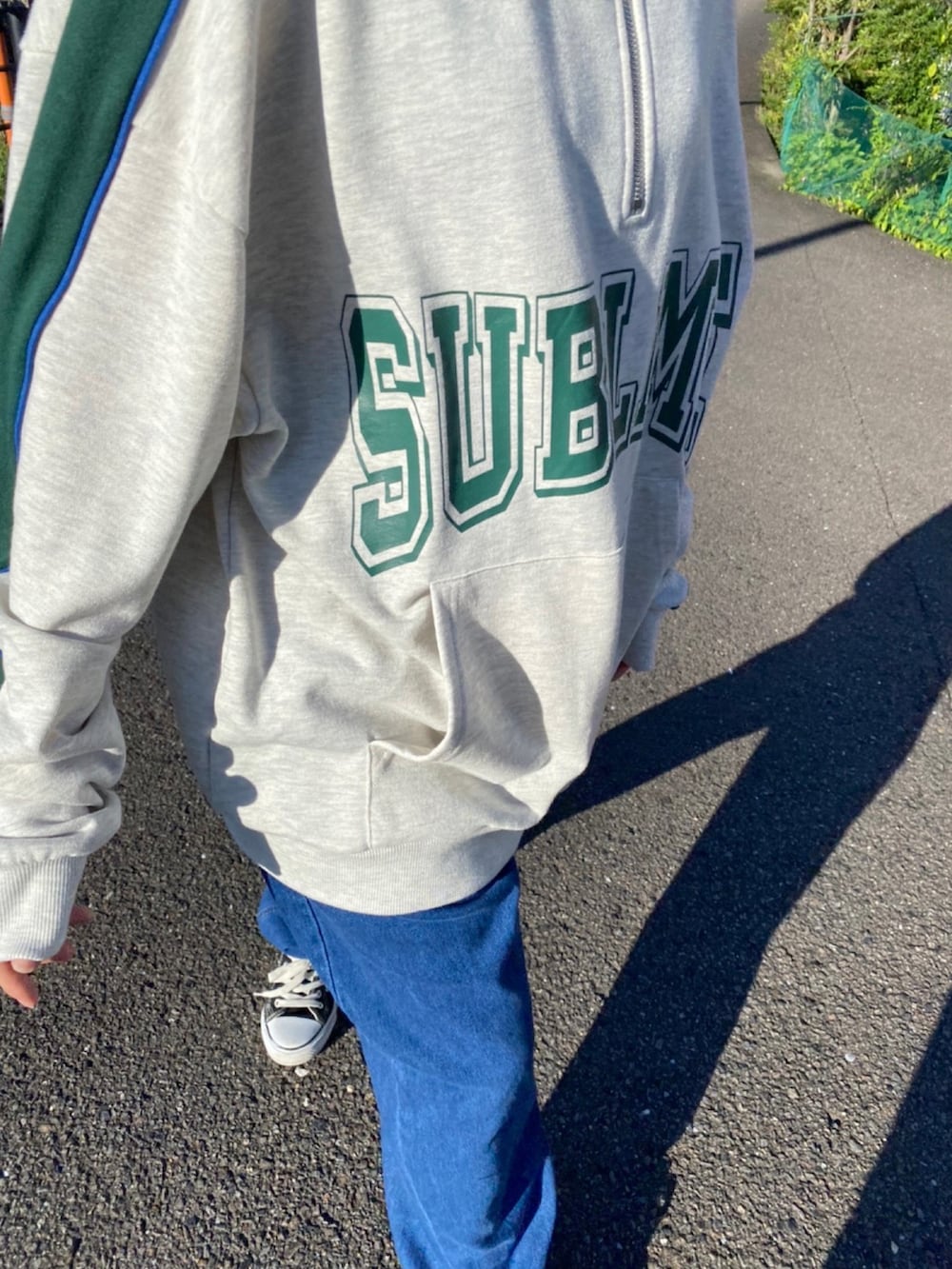 ブラック系のスニーカー、グレー系のスウェットを着用したレディースの夏コーディネートの3枚目の写真