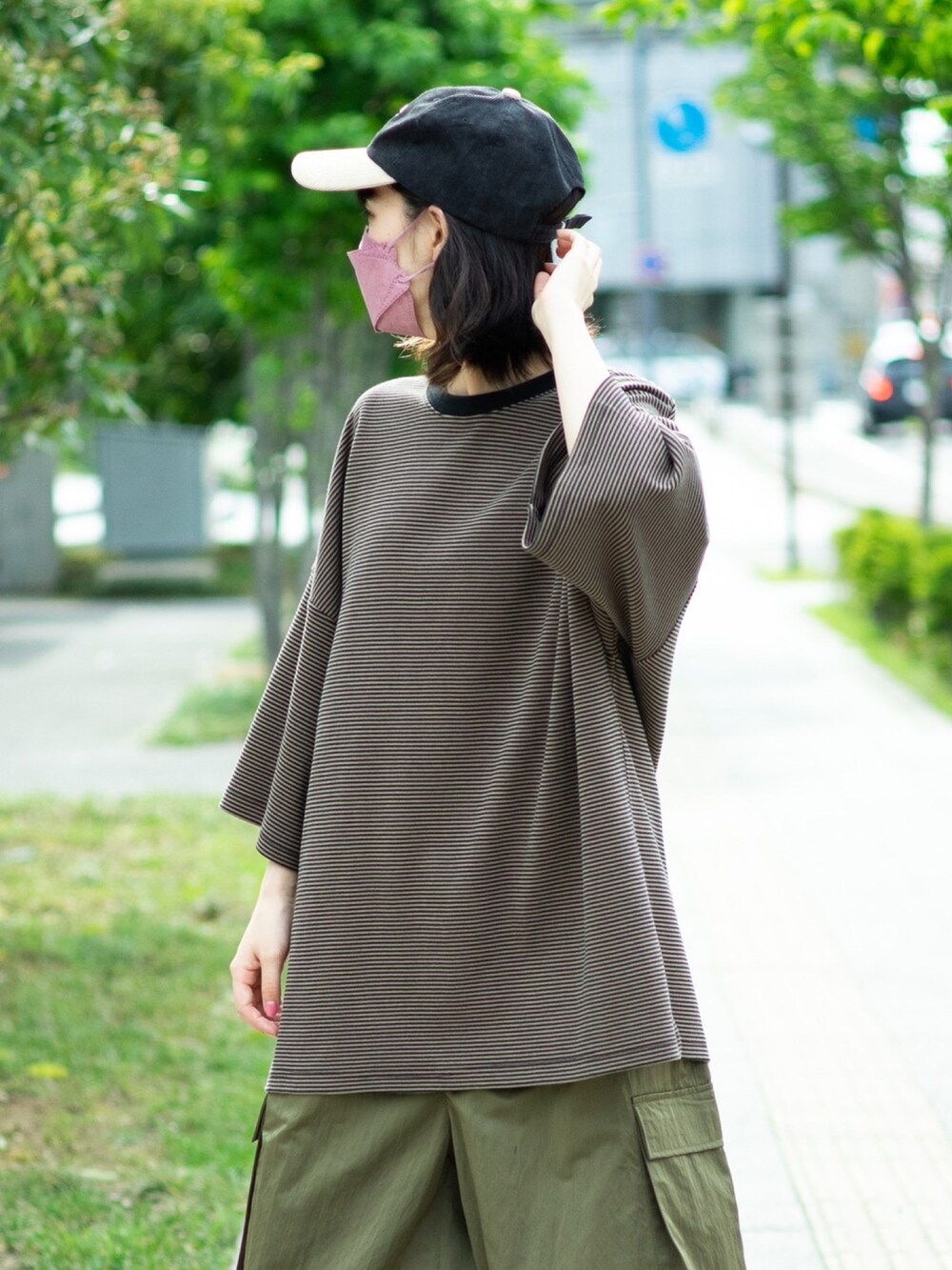 ブラウン系のTシャツ/カットソー、グリーン系のカーゴパンツ、ブラック系のブーツを着用したレディースの春コーディネートの3枚目の写真