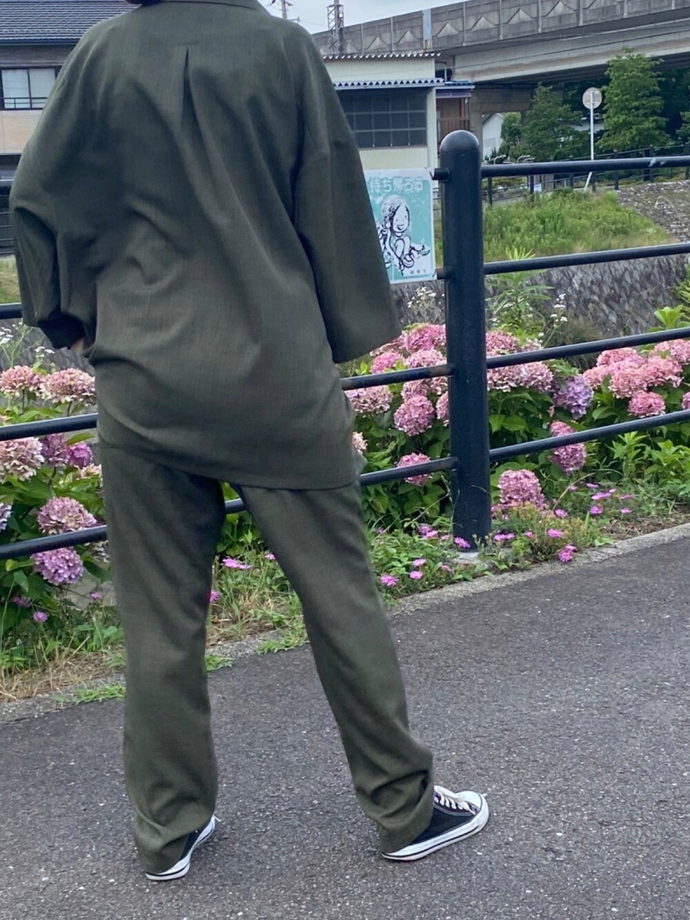 ブラック系のスニーカー、グリーン系のセットアップを着用したレディースの夏コーディネートの3枚目の写真