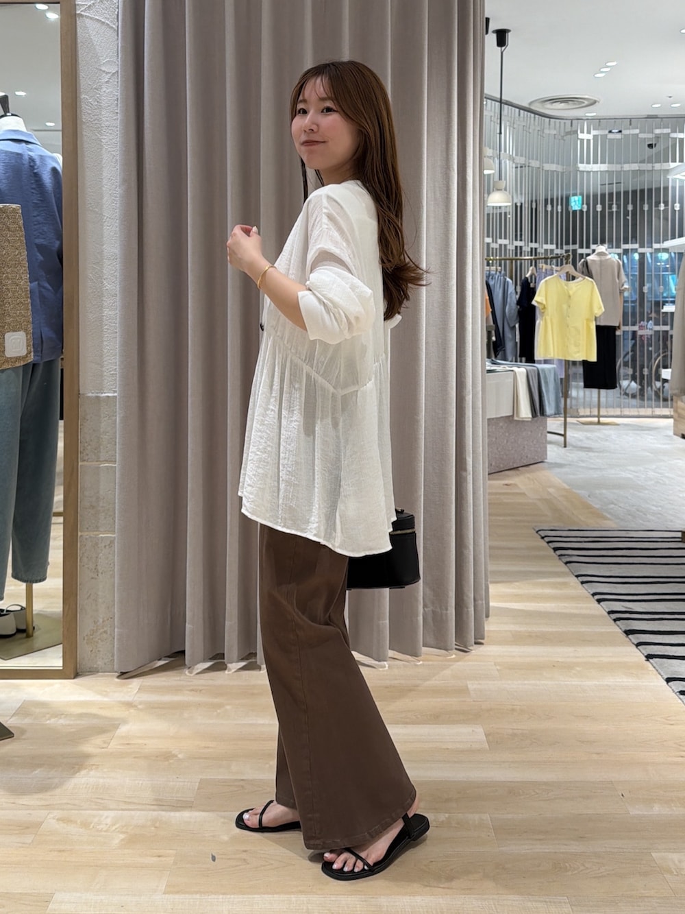 ホワイト系のシャツ/ブラウス、ホワイト系のタンクトップ、ブラウン系のデニムパンツを着用したレディースの夏コーディネートの2枚目の写真