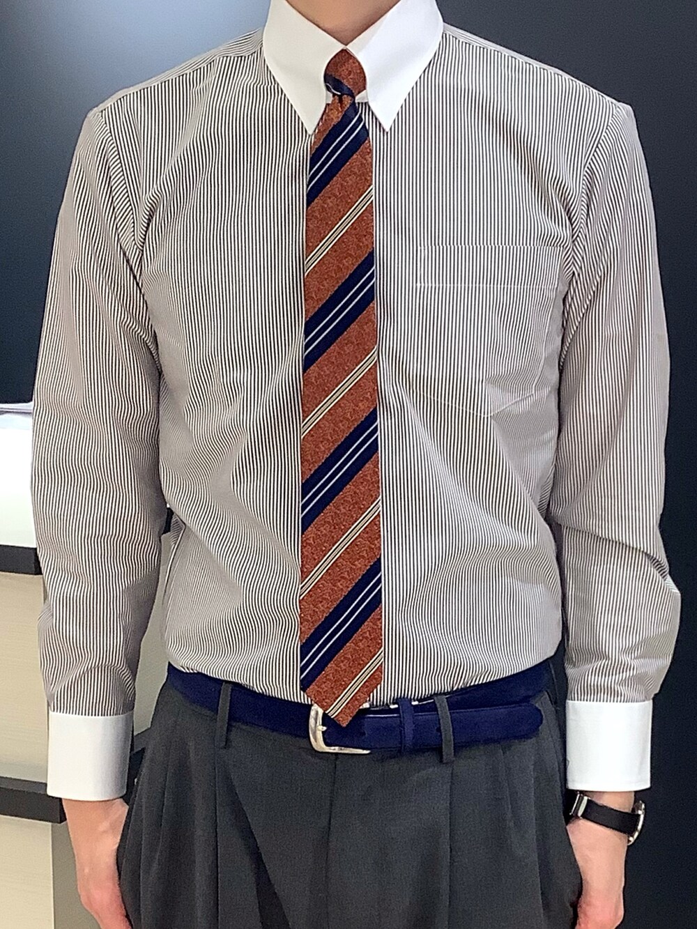 オレンジ系のネクタイ、ブラウン系のビジネスシャツ、ブラウン系のベストを着用したメンズの冬コーディネートの3枚目の写真