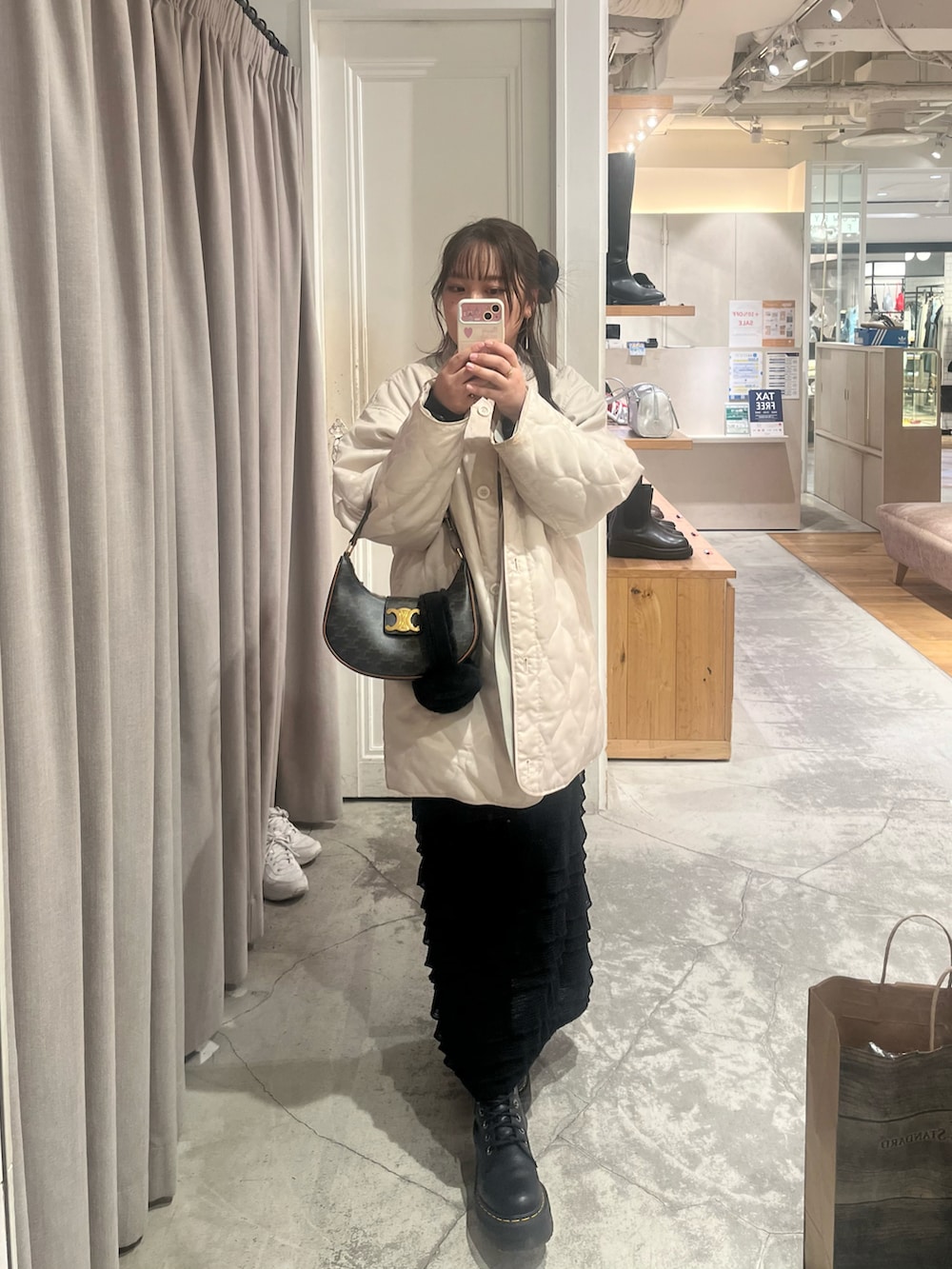 ブラウン系のハンドバッグ、ブラック系のスカート、グリーン系のテーラードジャケットを着用したレディースの冬コーディネートの2枚目の写真