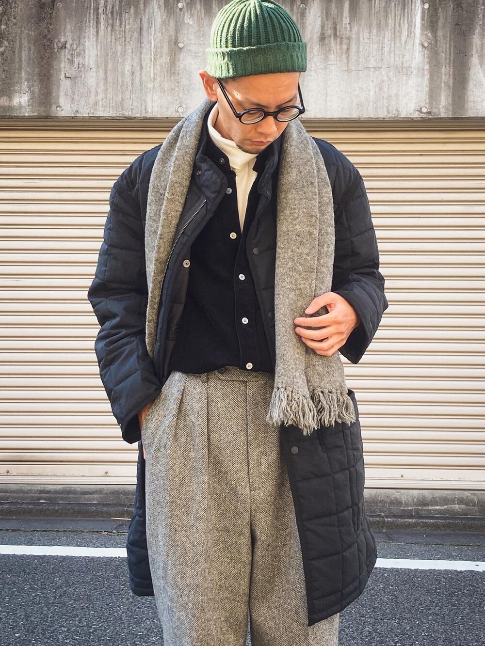 グレー系のスラックス、ブラック系のスニーカー、ブラック系のシャツ/ブラウスを着用したメンズの秋コーディネートの2枚目の写真