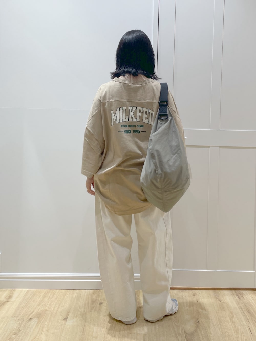 ベージュ系のTシャツ/カットソー、ベージュ系のショルダーバッグ、ホワイト系のデニムパンツを着用したレディースの春コーディネートの2枚目の写真