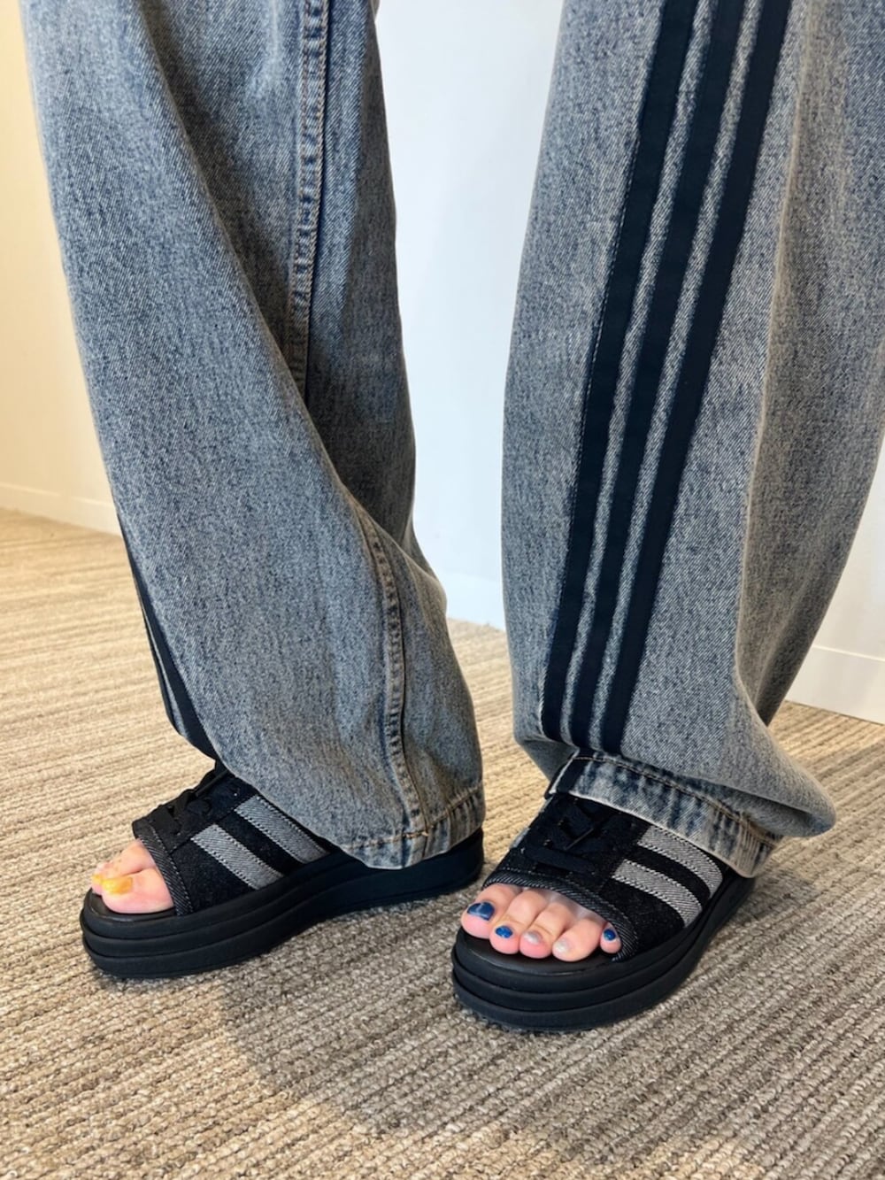 ホワイト系のジャージ、ブラウン系のデニムパンツ、ホワイト系のトートバッグを着用したレディースの春コーディネートの4枚目の写真